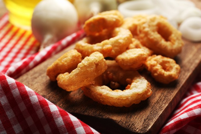 Chips rings with sauce and onion on cutting board