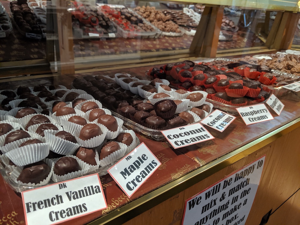 picture of a table full of chocolates: french vanilla creams, maple creams, coconut creams & raspberry creams