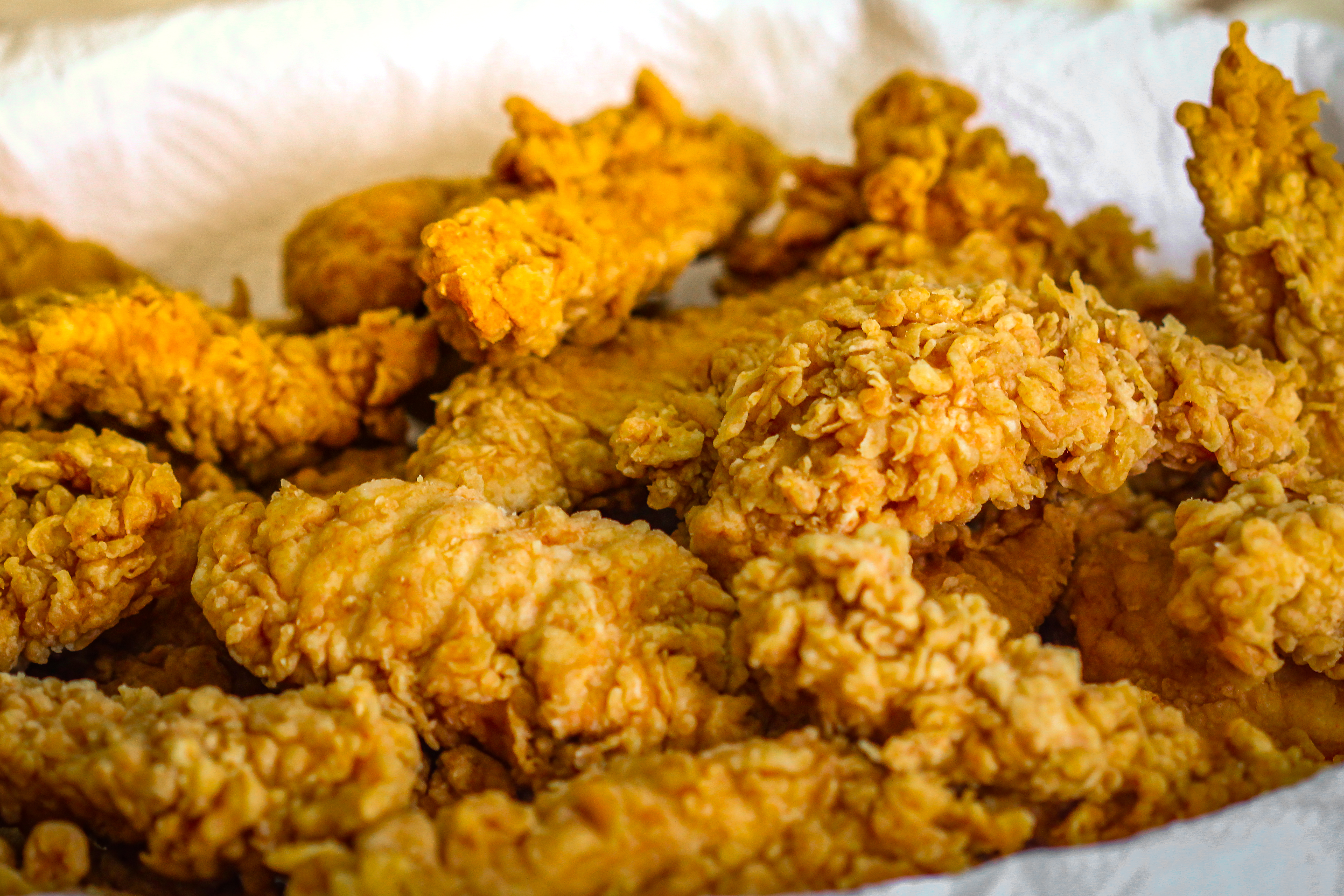 Fried chicken strips draining on a napkin.