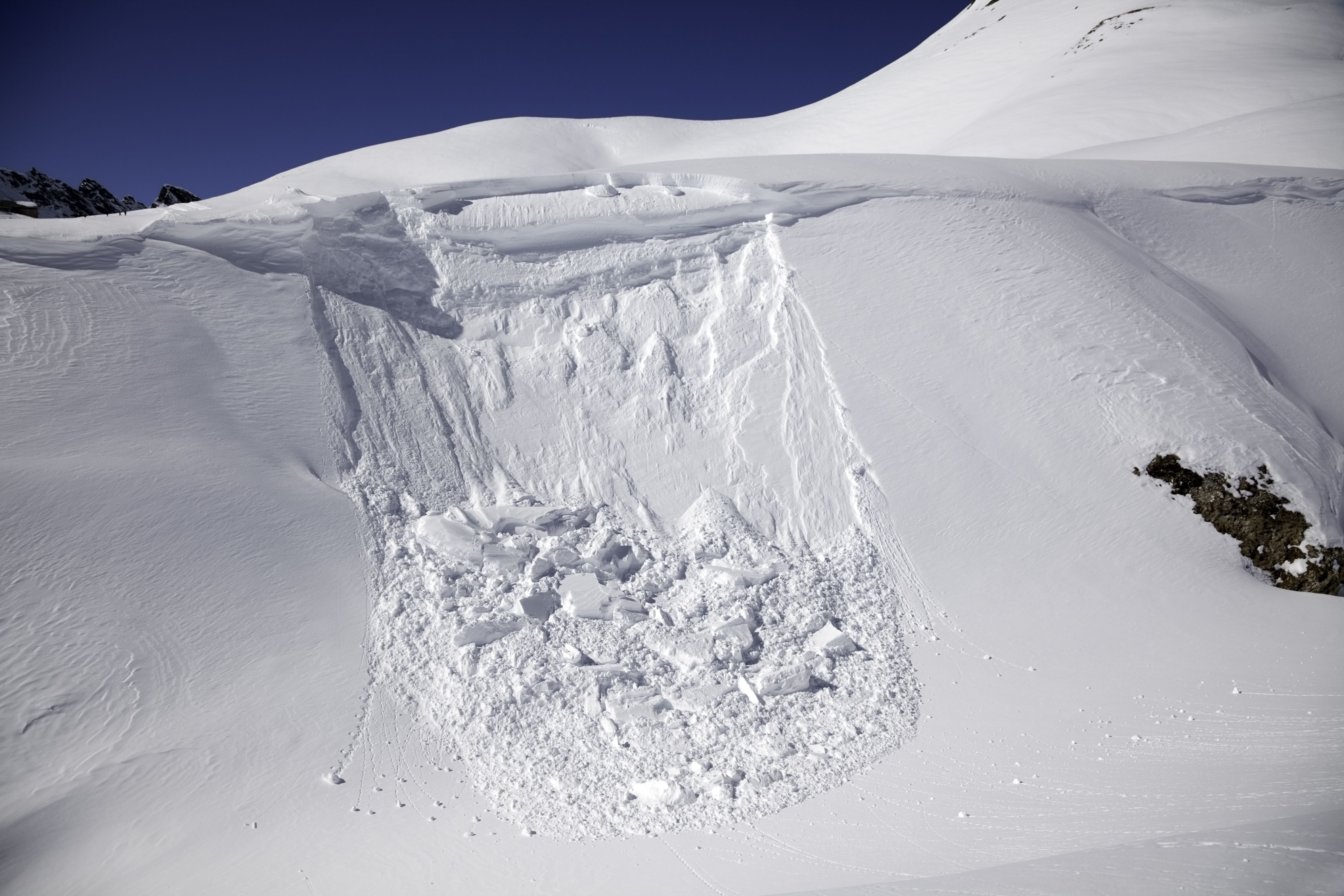 The start of an avalanche on a hillside.