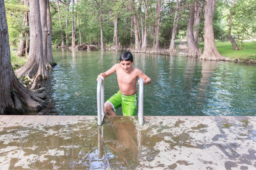 boy climbing ladder out of creek