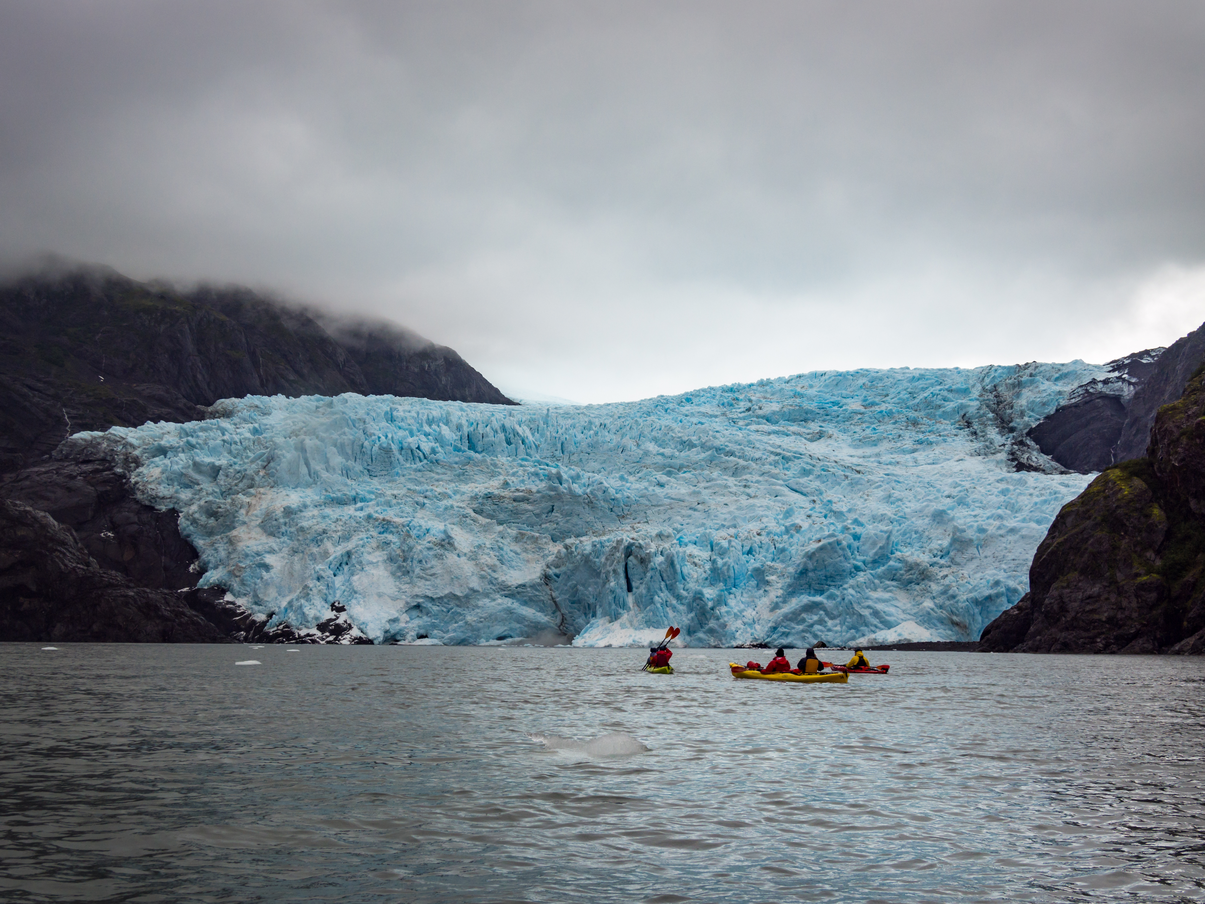Kayakers paddling near glaciers at Kenai Fjords National Park in Alaska.