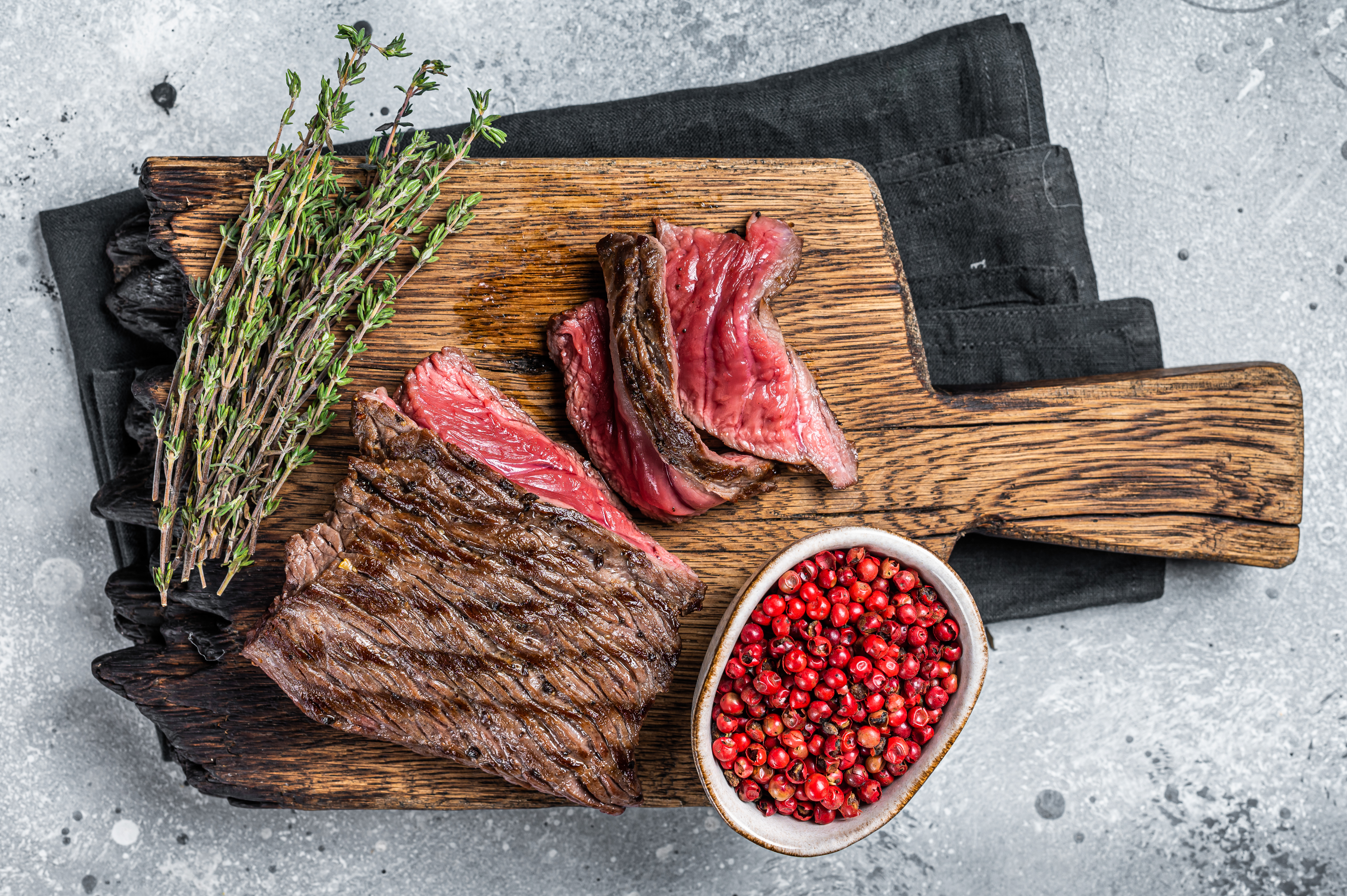 BBQ Grilled Wild Venison steak on wooden board. Gray background. Top view.