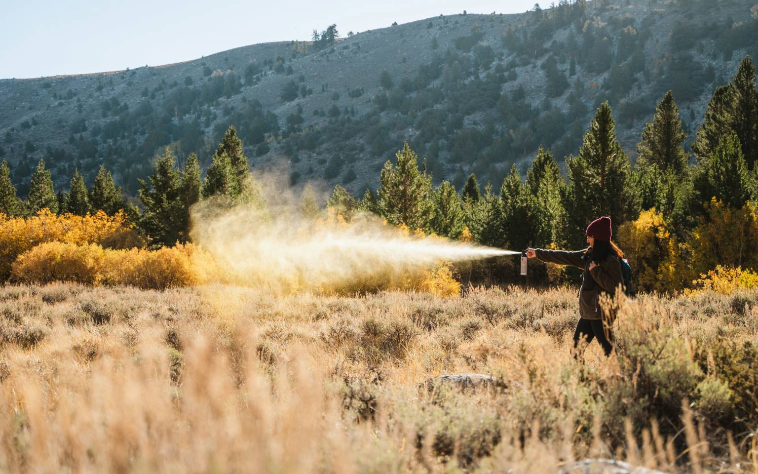woman outdoors spraying bear spray by sabre frontiersman