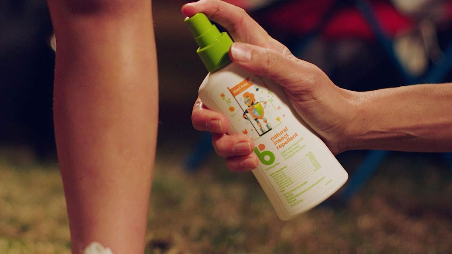Close up on hand spraying Babyganics Insect Spray onto leg 