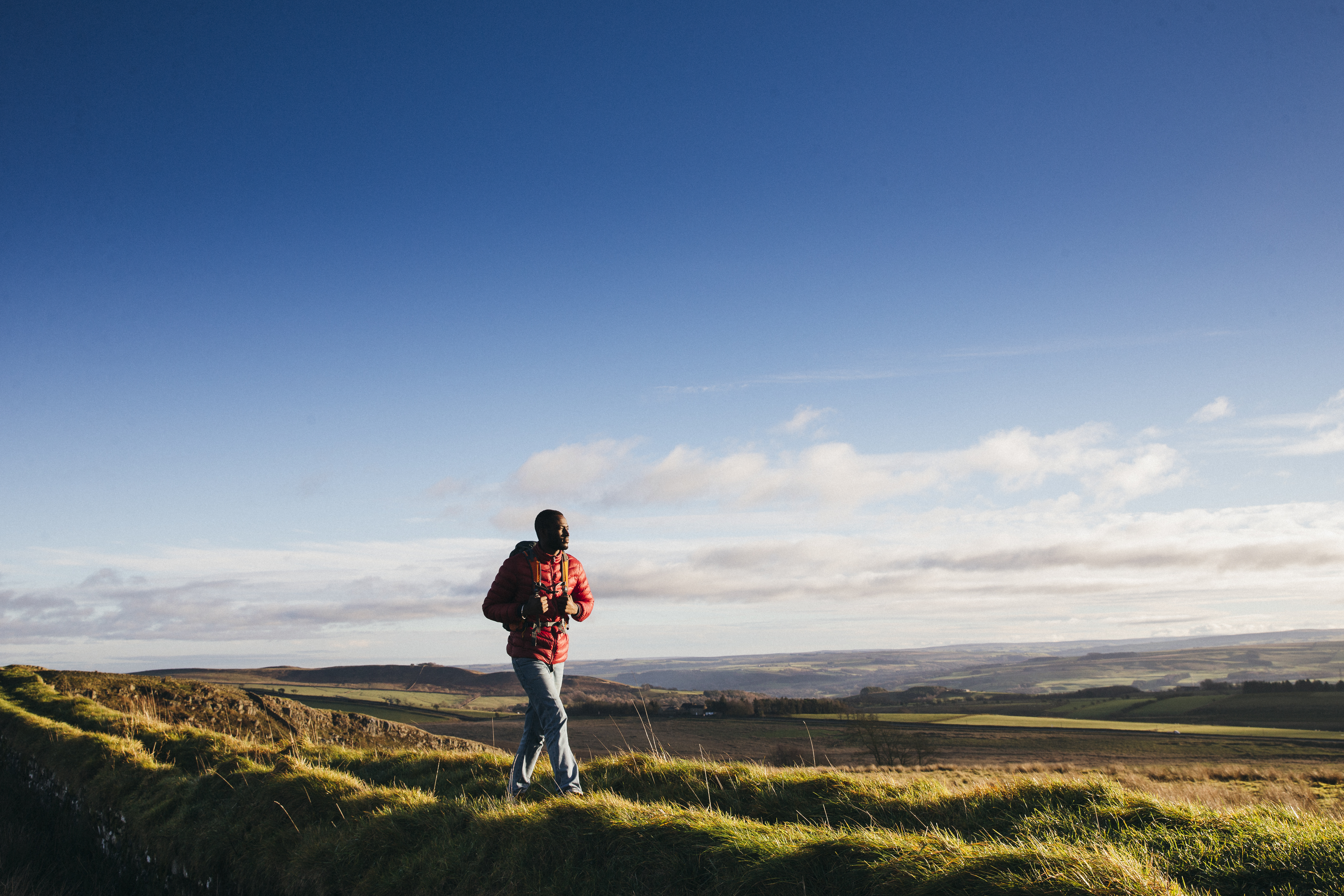 One young adult walking on Hadrian's Wall in Northumberland, UK countryside.