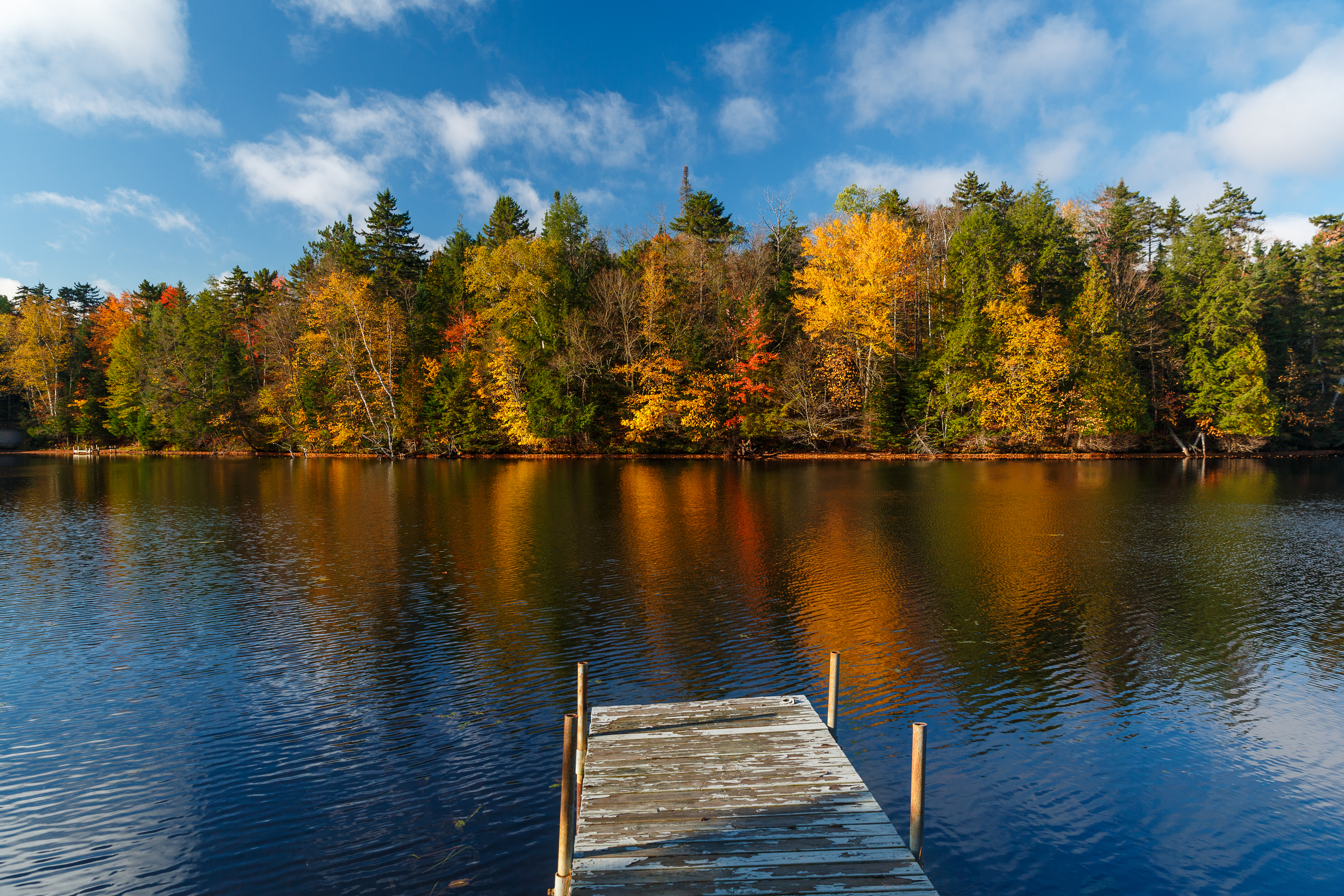 Worn dock on Chateaugay lake, upstate New York in Autumn
