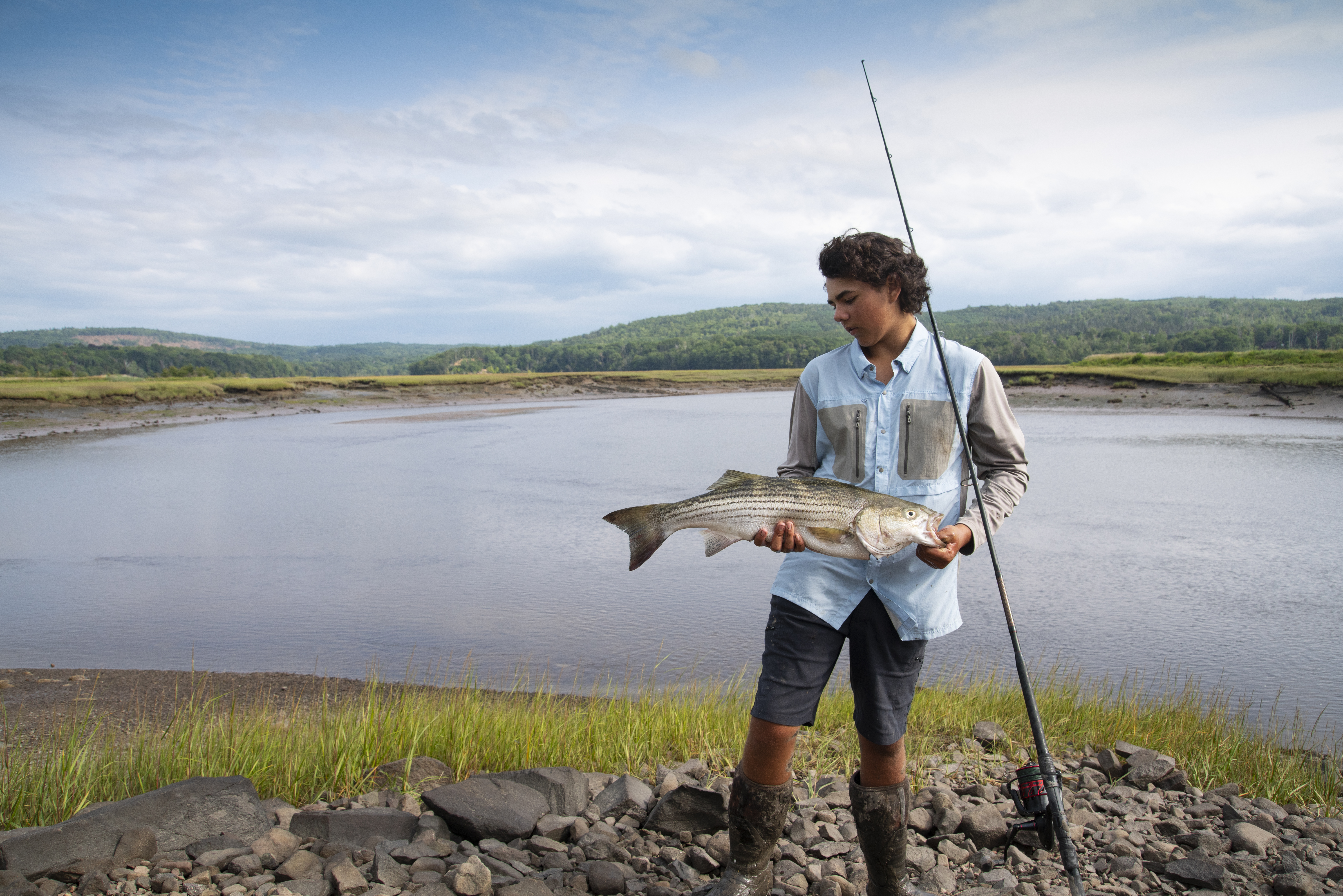 A beautiful 30" striped bass caught in a tidal river by a teen fisherman