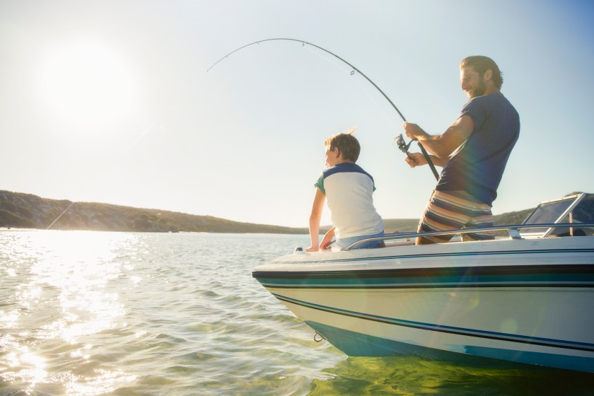 Father and son fishing on boat