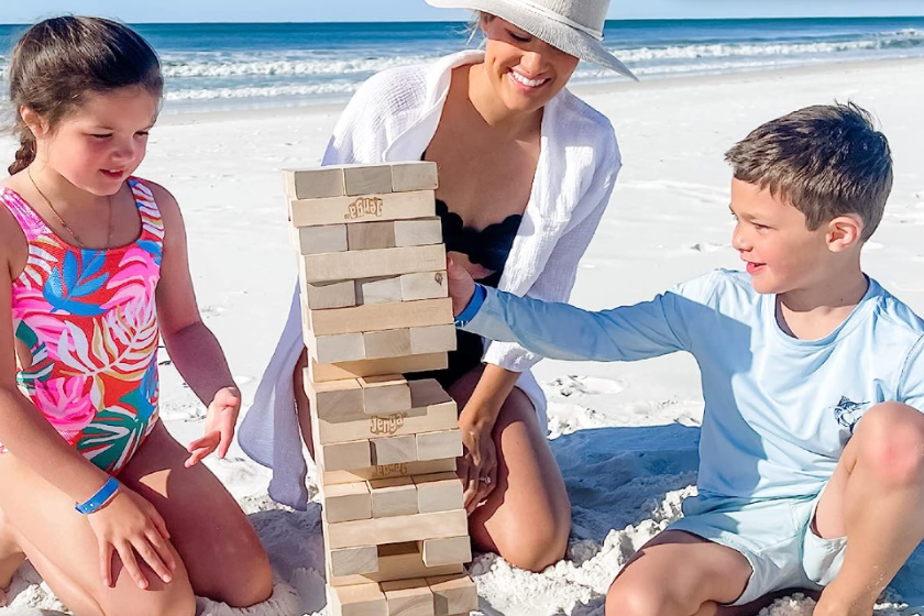 A mother and her two children playing on the beach.