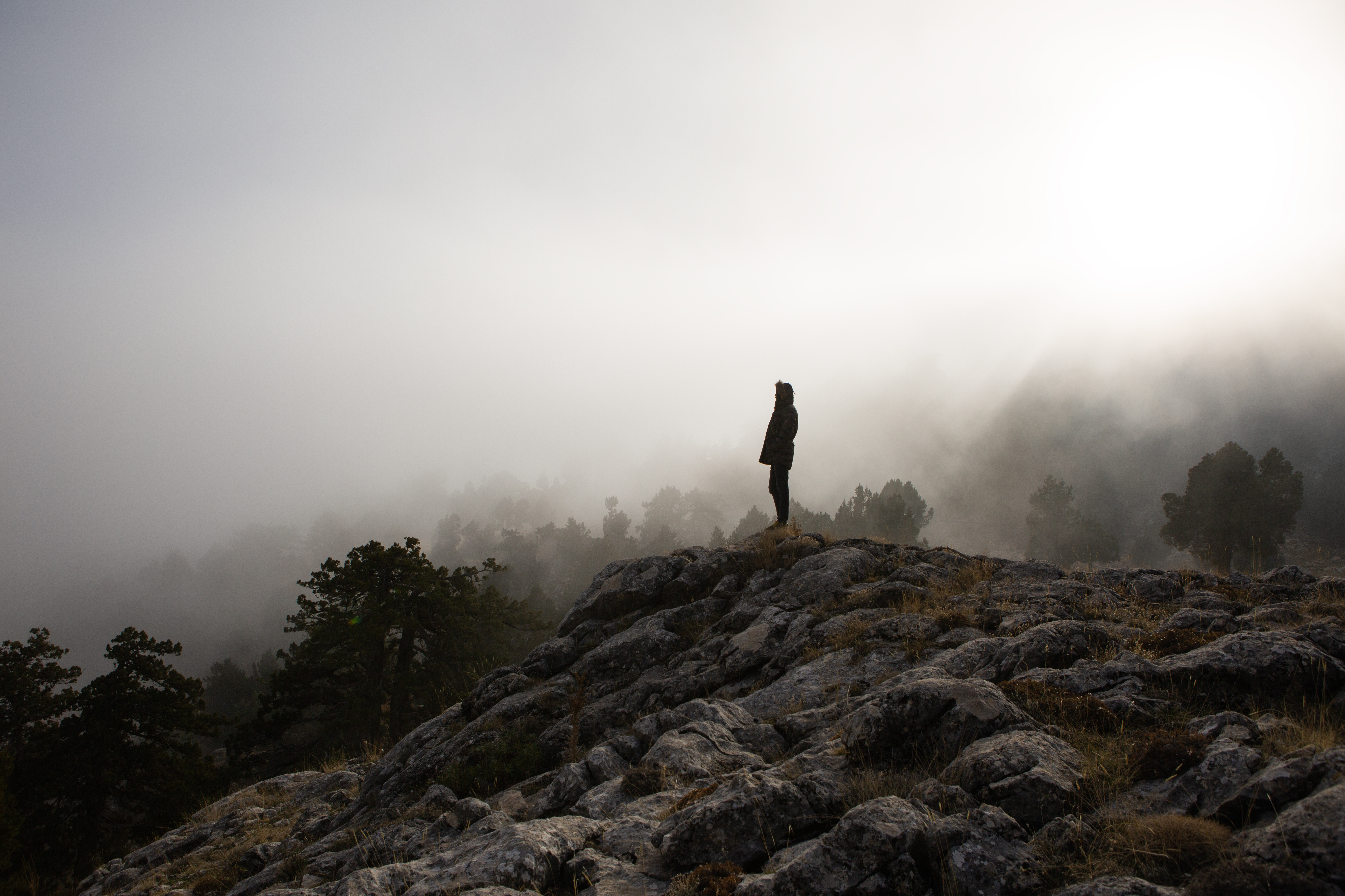 Landscape with traveler, foggy hills, amazing sky and sunlight in fall.
