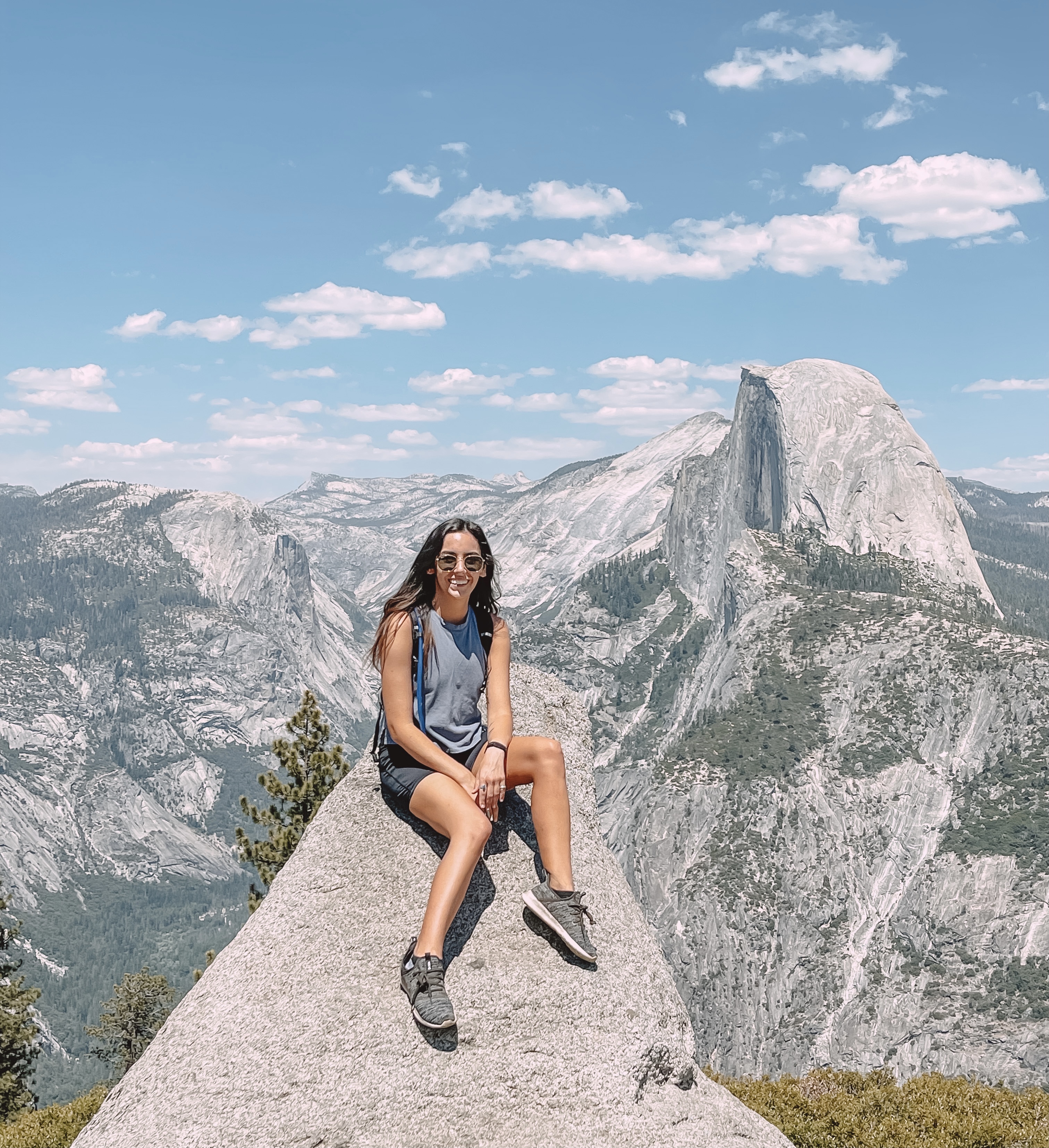 Author wearing a backpack and sitting on a rock in Yosemite National Park