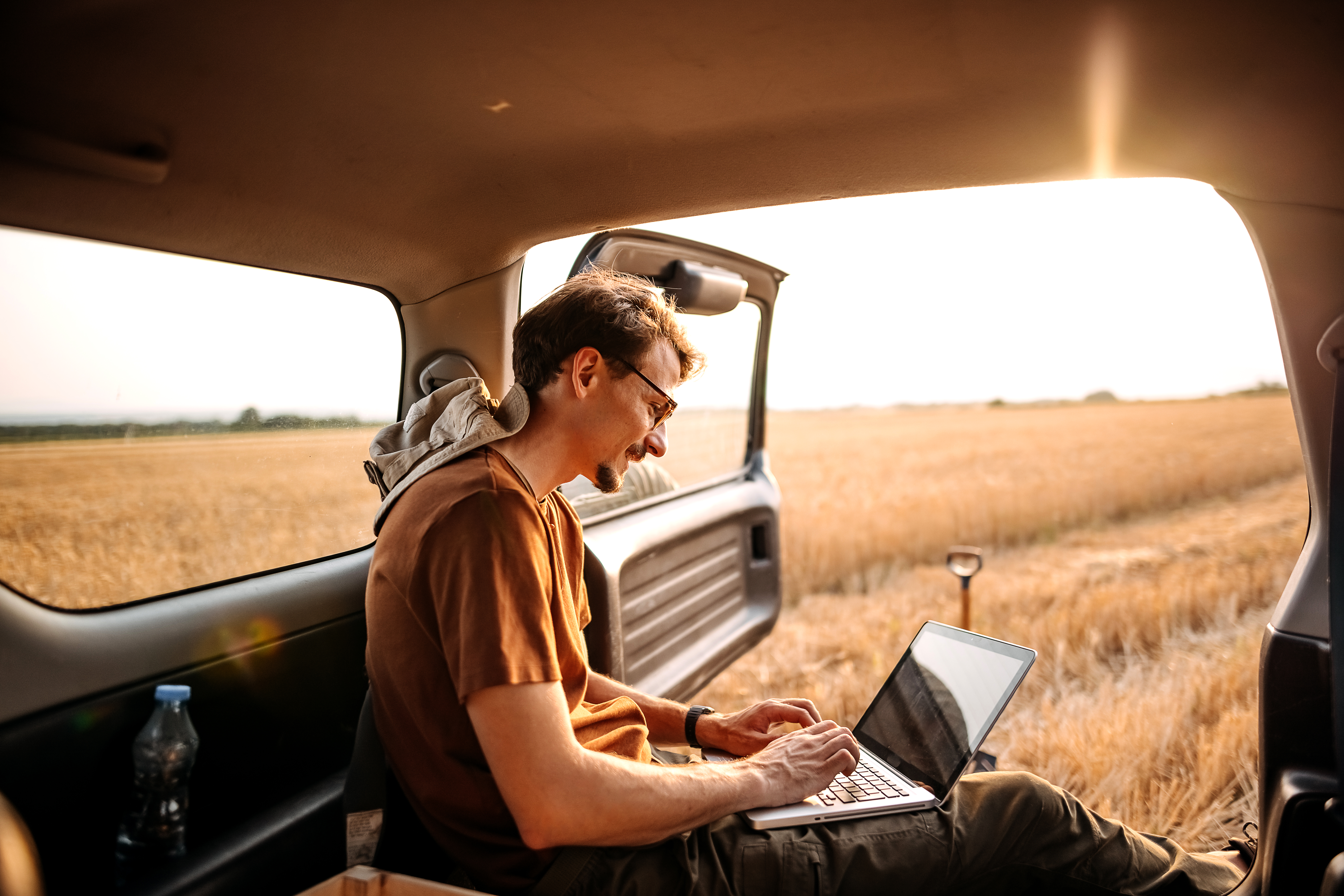 Young farmer collecting data of his field on laptop