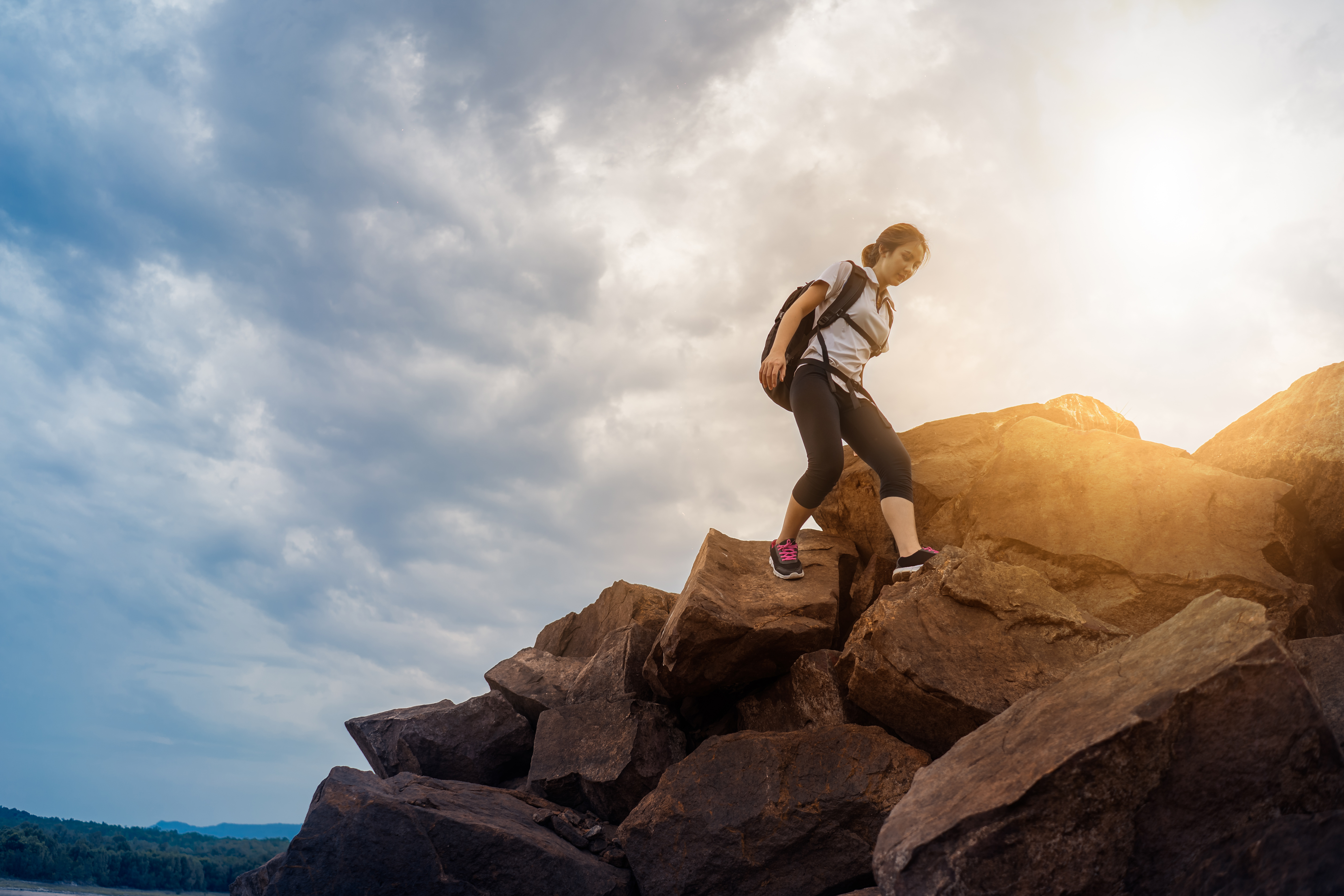 Traveler Asian woman backpack adventure climbing on the mountain with gold sunlight. hike adventure concept. 
