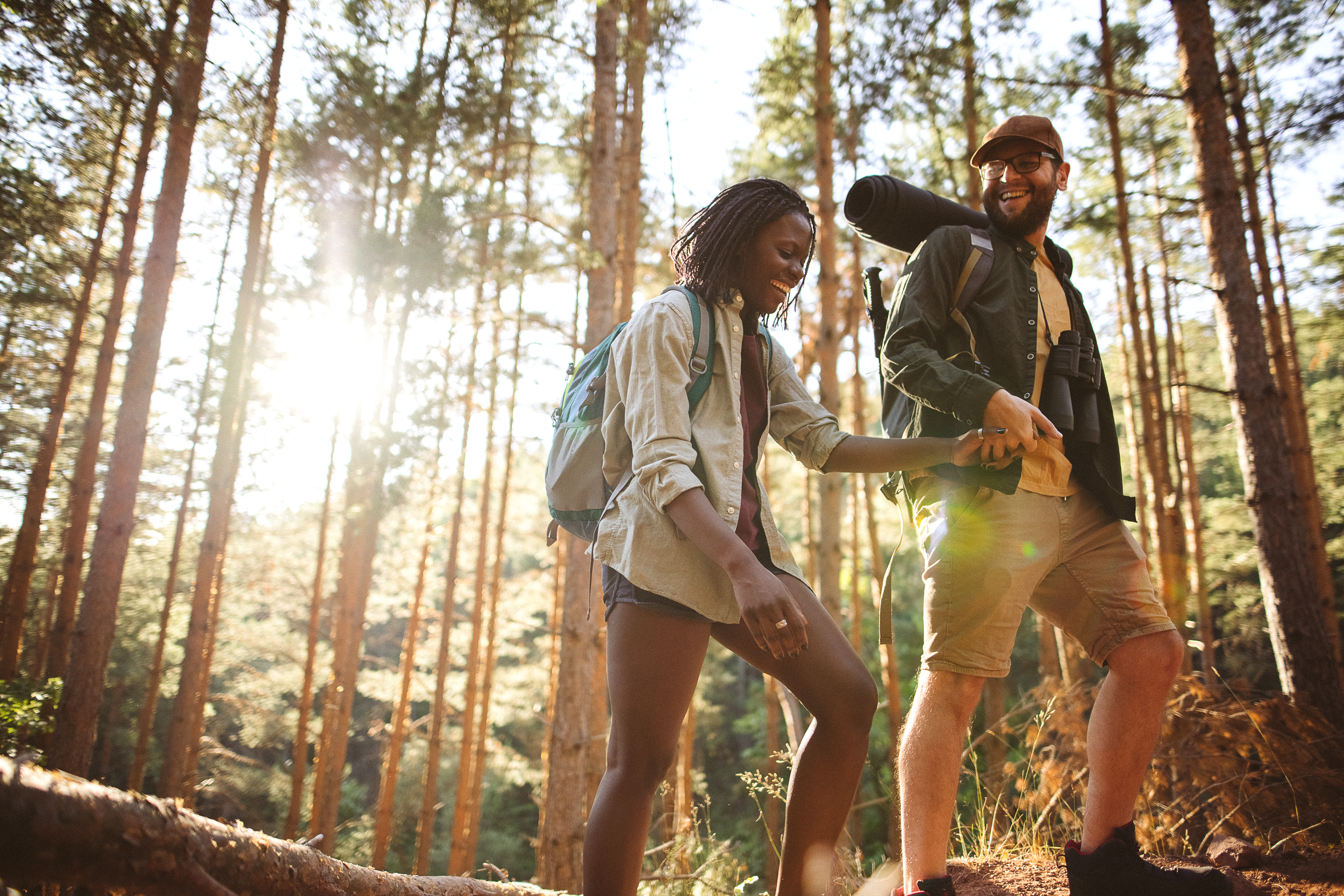 Man and woman hiking in the forest, backpacking, walking and speaking for a good place for camping