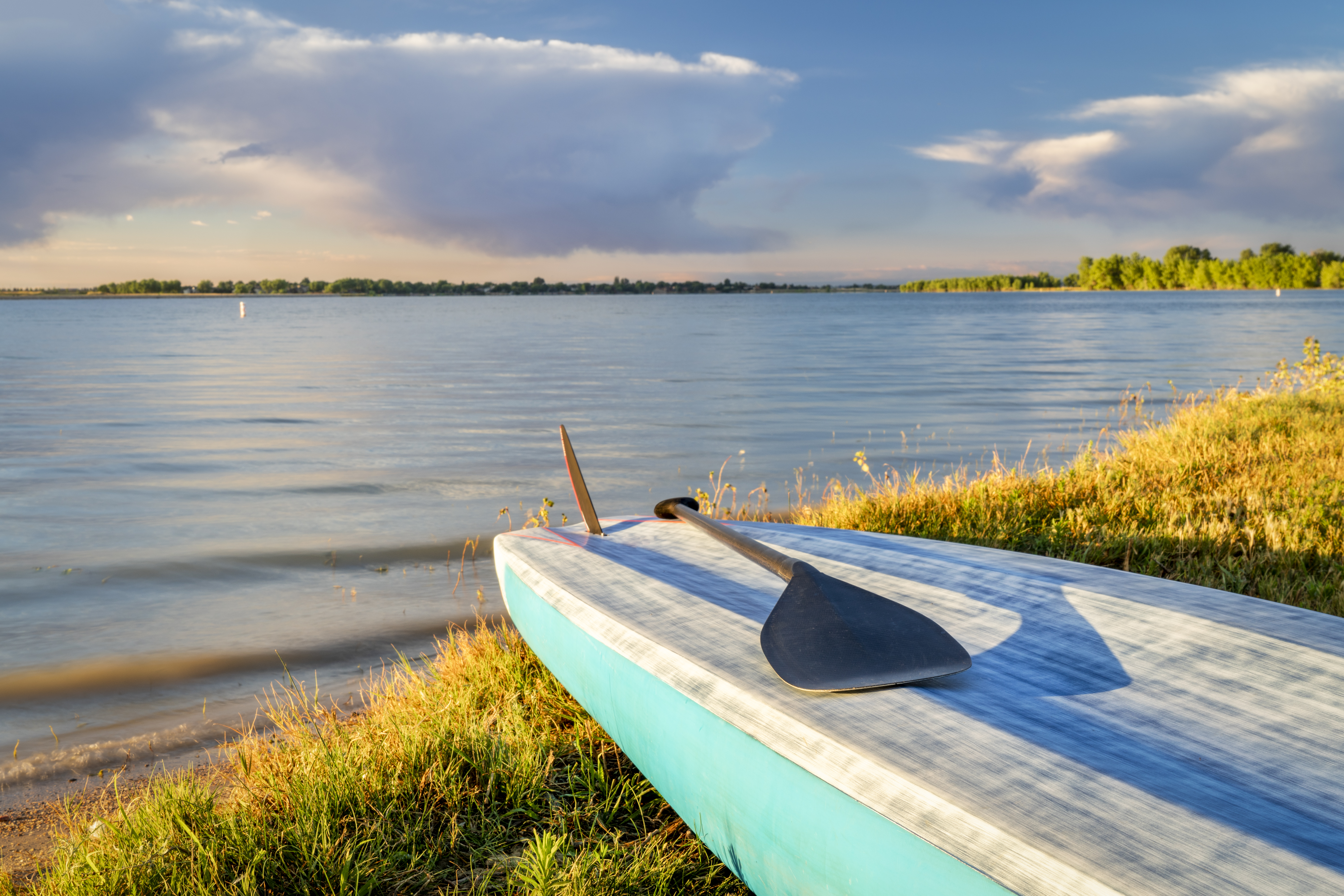 stand up paddleboard with a paddle on a lake shore in Colorado (Boyd Lake State Park), summer scenery. Colorado campsites