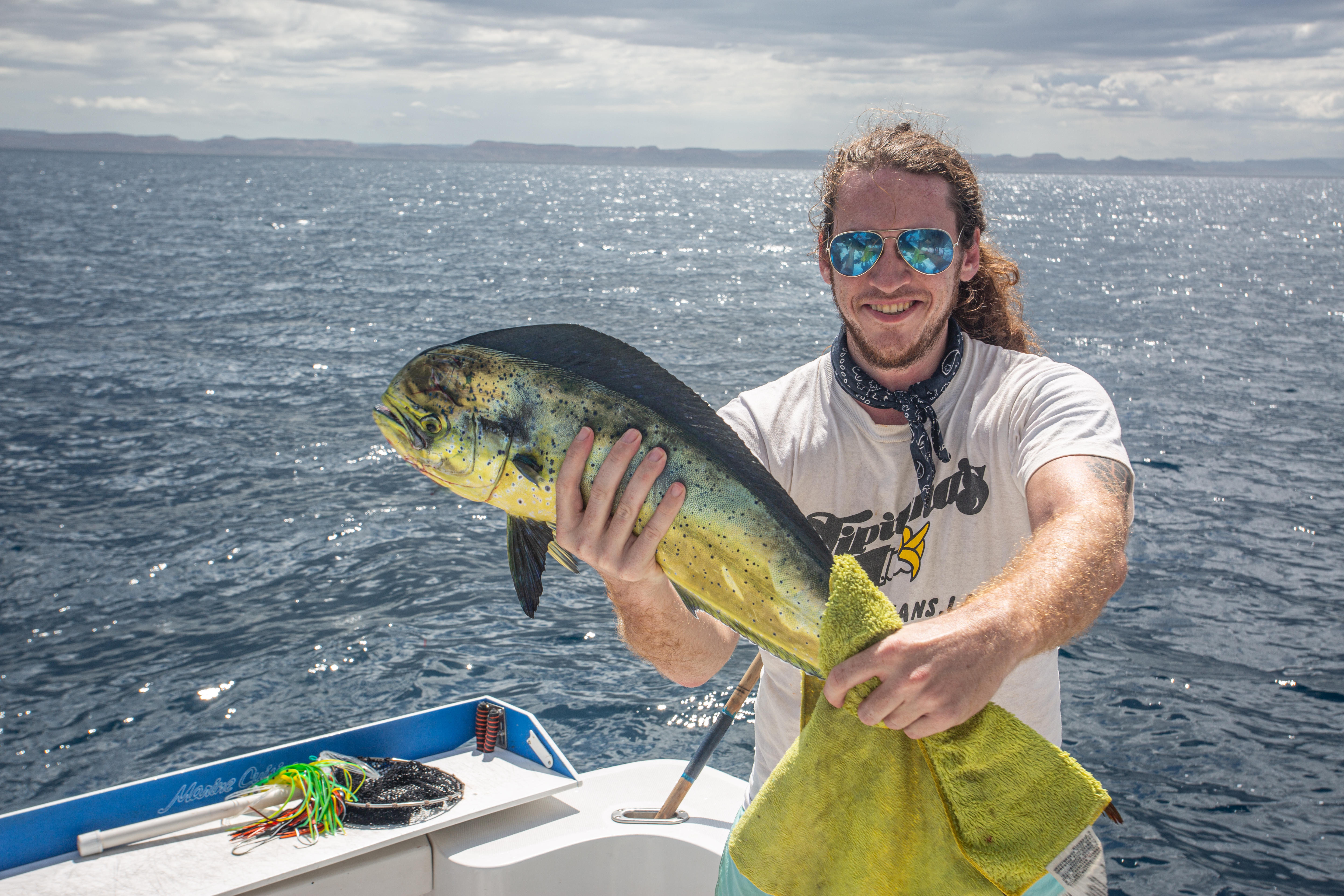 Person holding up a large fish inside a boat