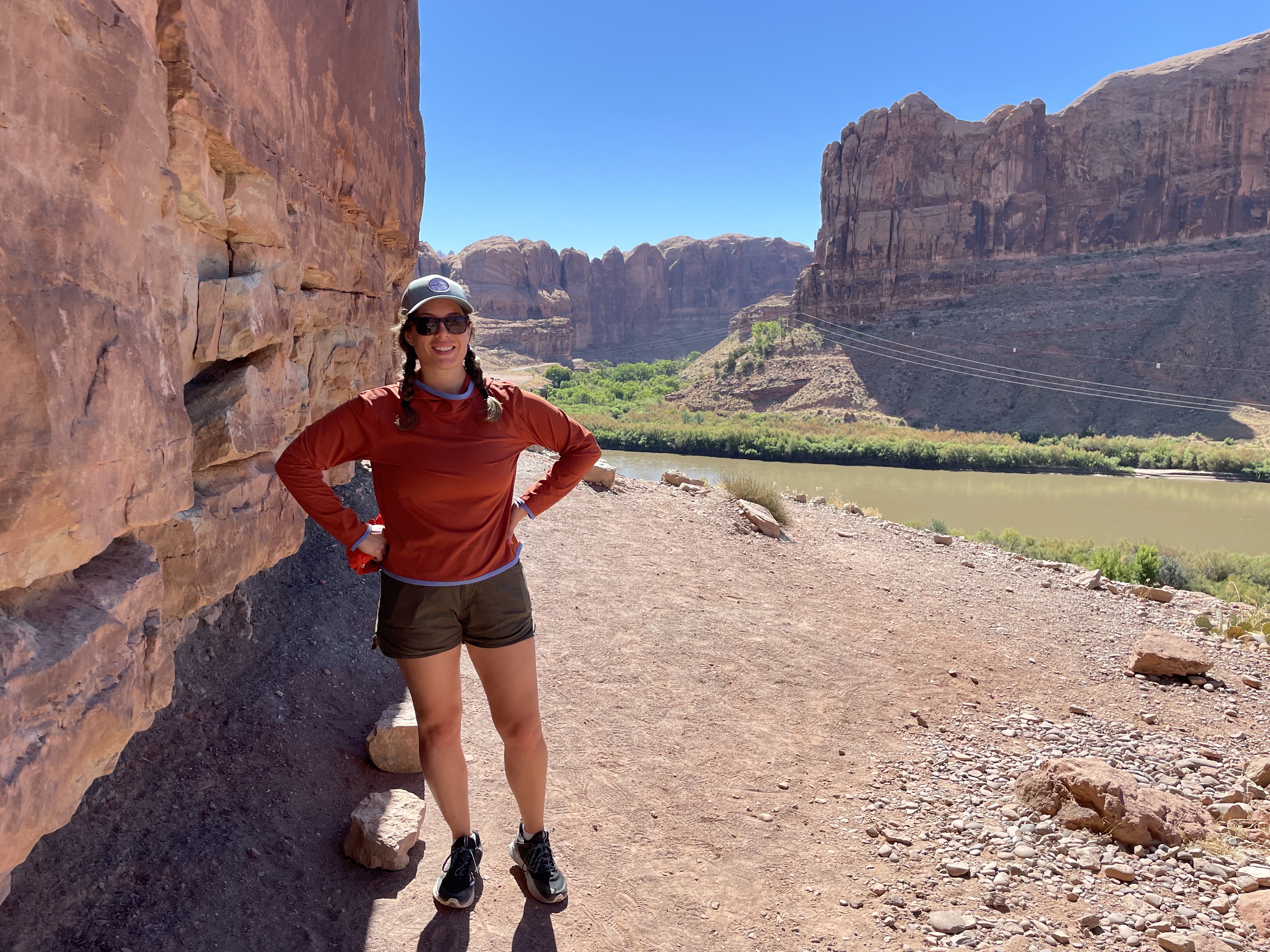 Author hiking in a canyon while wearing a burnt orange sun hoodie