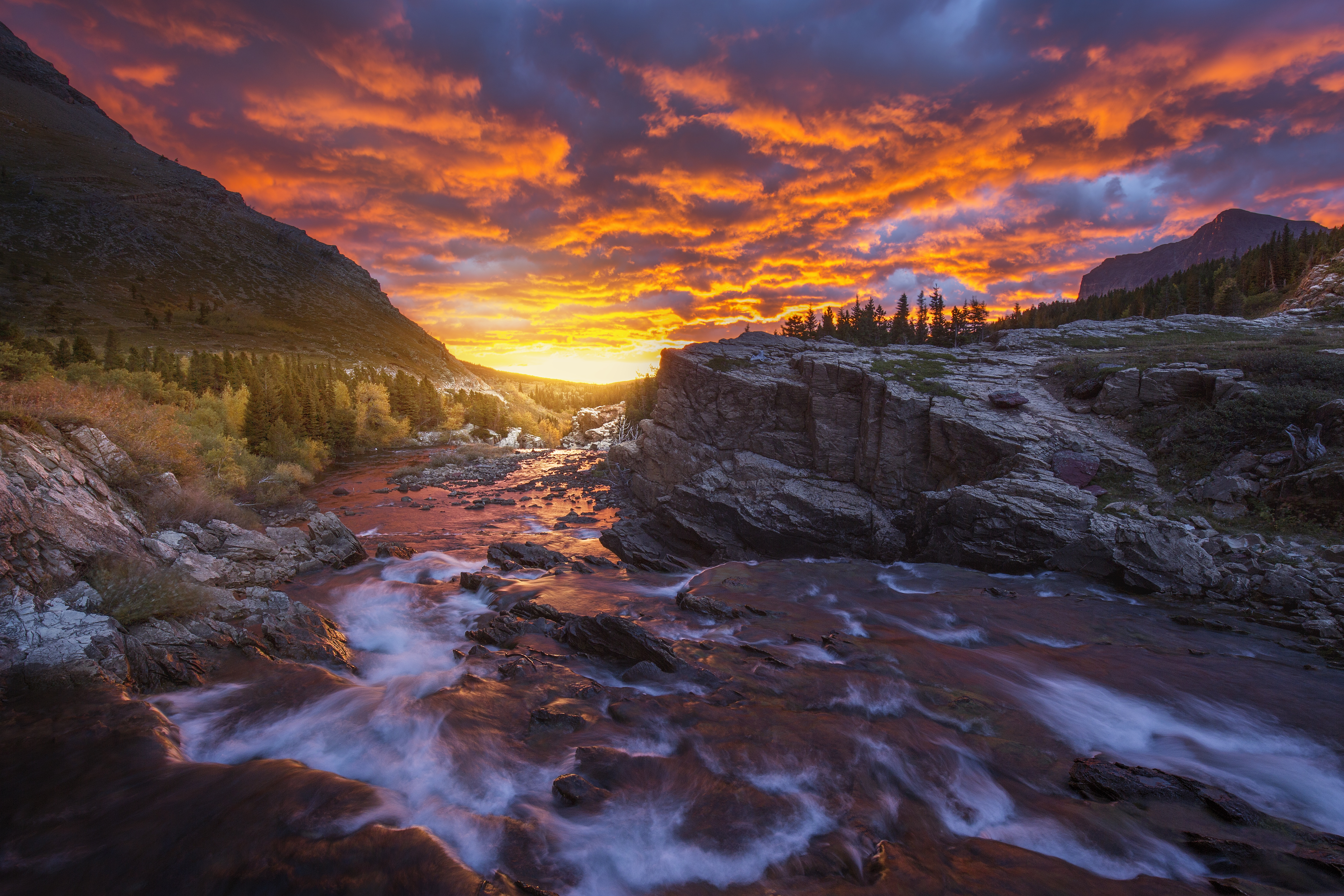 Fiery sunrise at Swiftcurrent Falls in Many Glacier, Glacier National Park, Montana