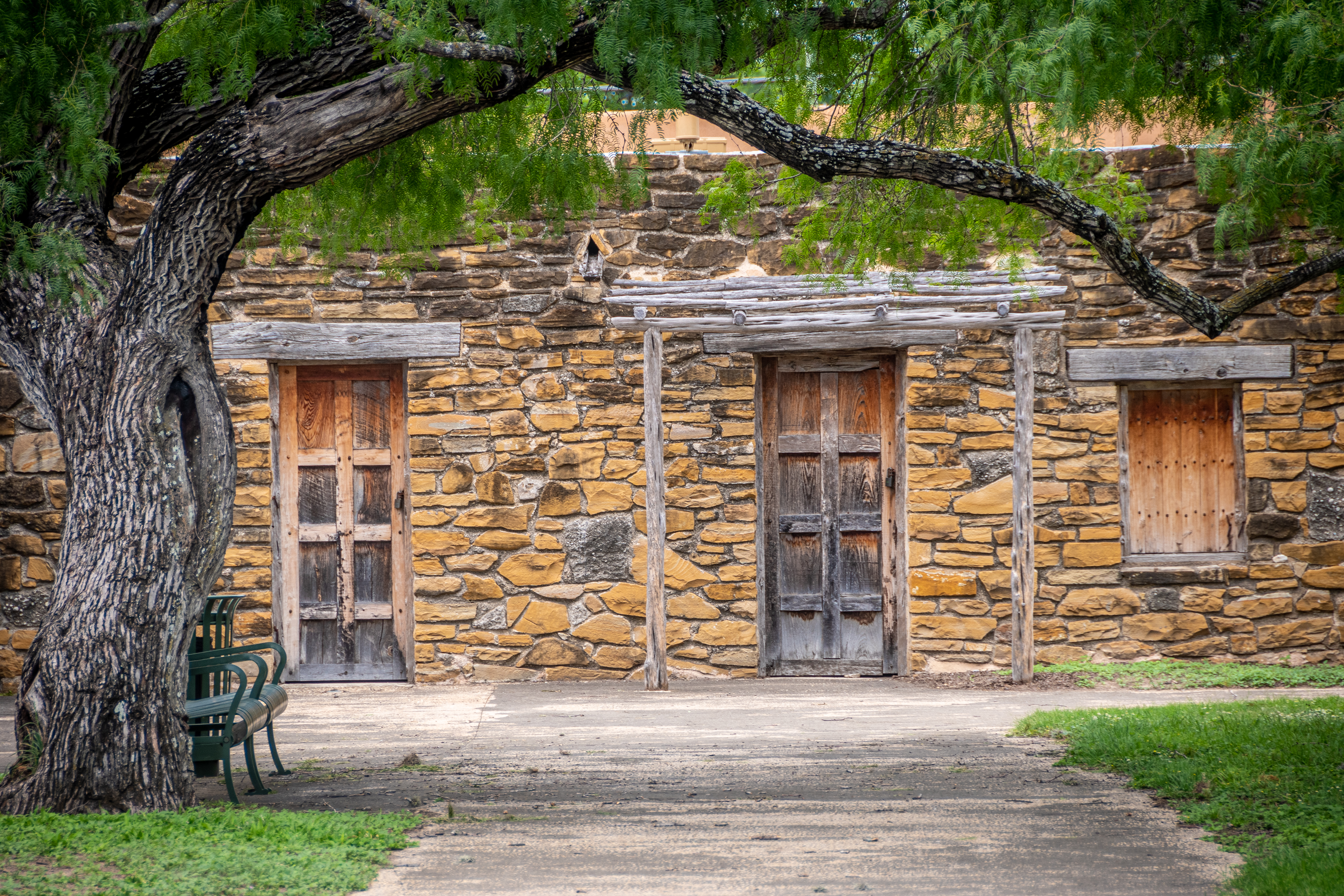 An historic building in San Antonio Missions National Historical Park beneath a large tree. (Photo by: Edwin Remsberg/VW Pics/Universal Images Group via Getty Images)