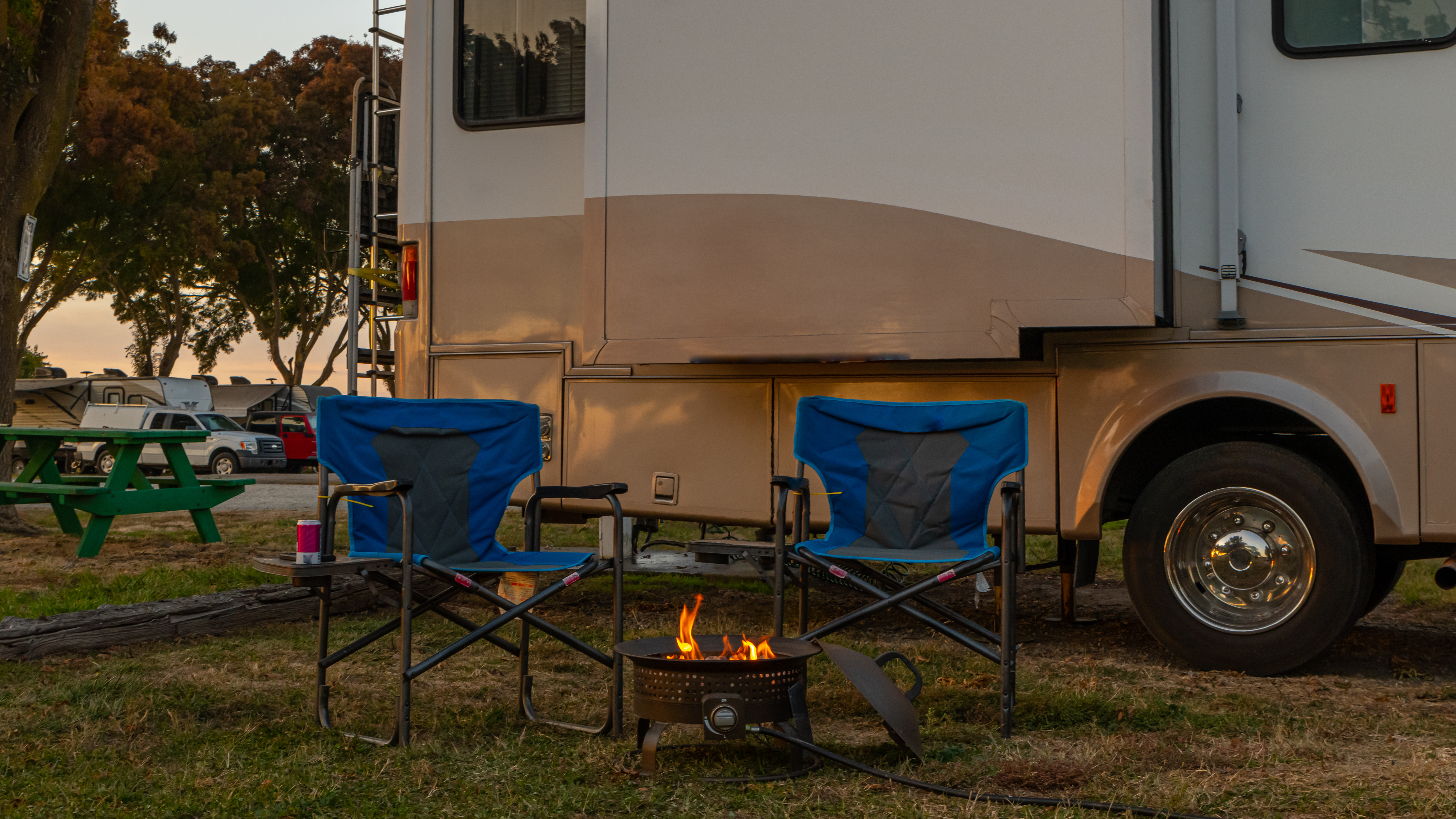 Chairs for sitting at a campfire at campsite next to Rv motorhome