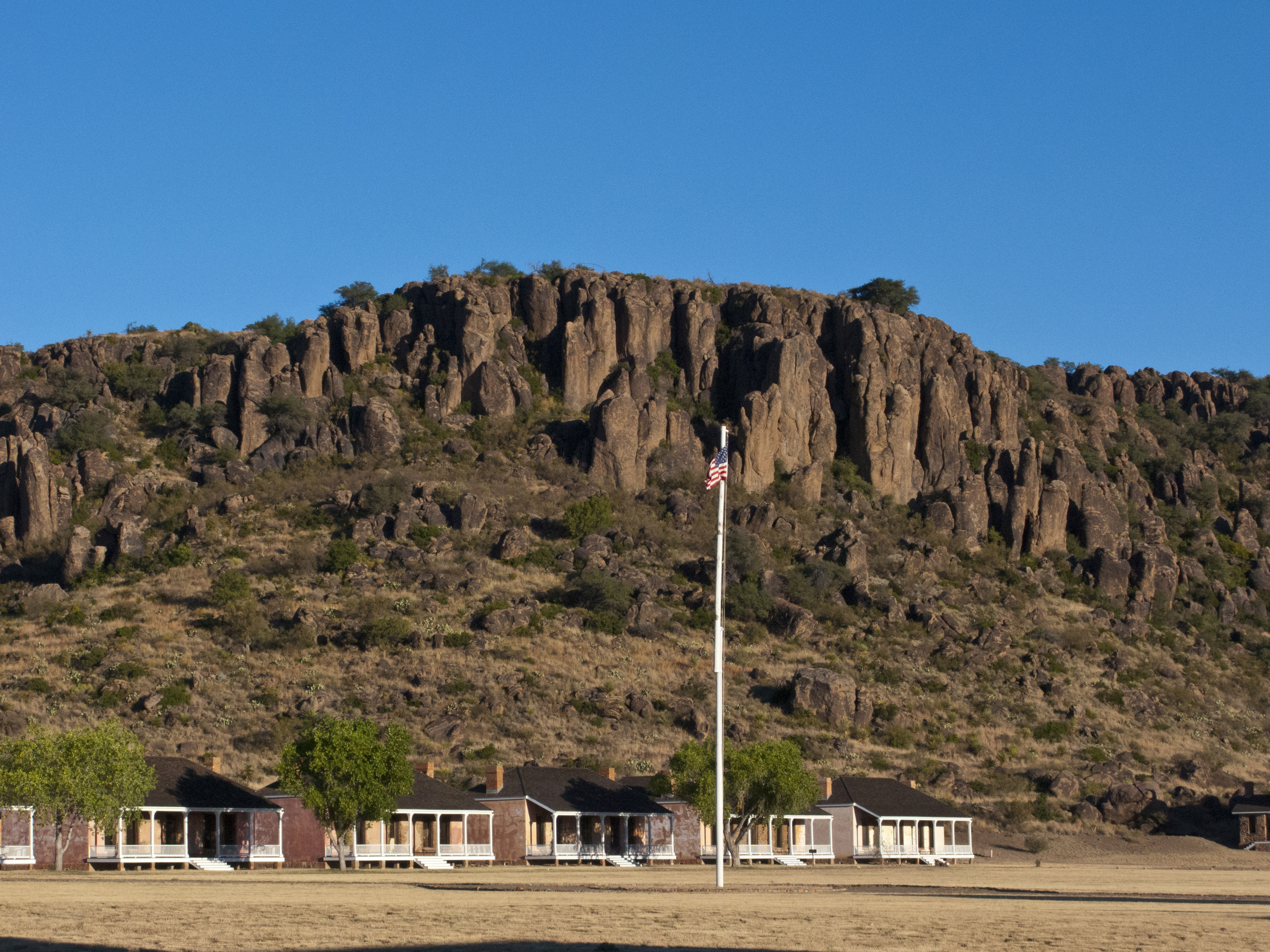 North America, USA, Fort Davis National Historic Site, Texas, Parade Grounds, Restored Officers Kitchen and Servants Quarters Framed by Davis Mountains Park Ridge. (Photo by: Education Images/Universal Images Group via Getty Images)