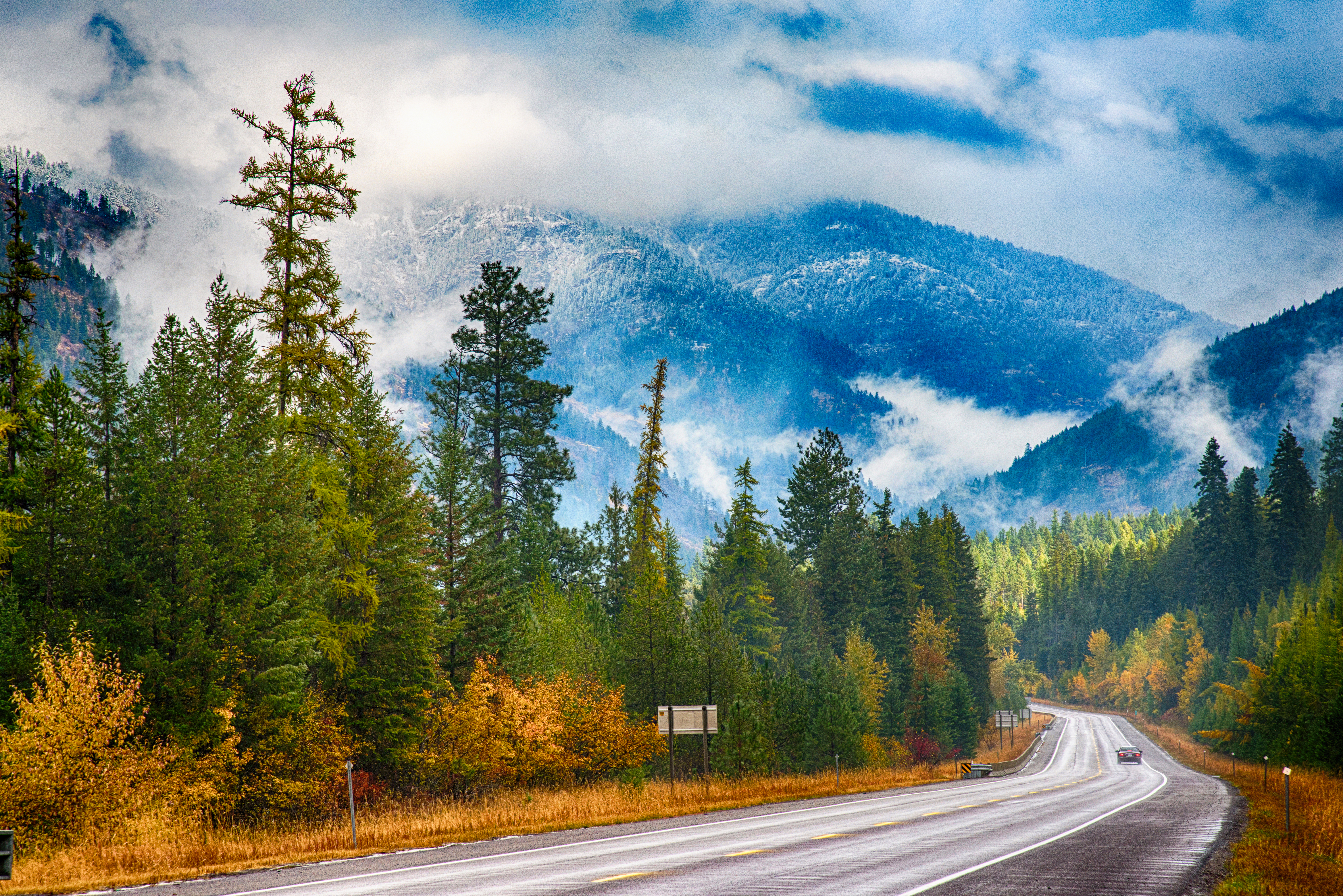 A two lane road in the western portion of the state of Montana close to the border of Idaho.
