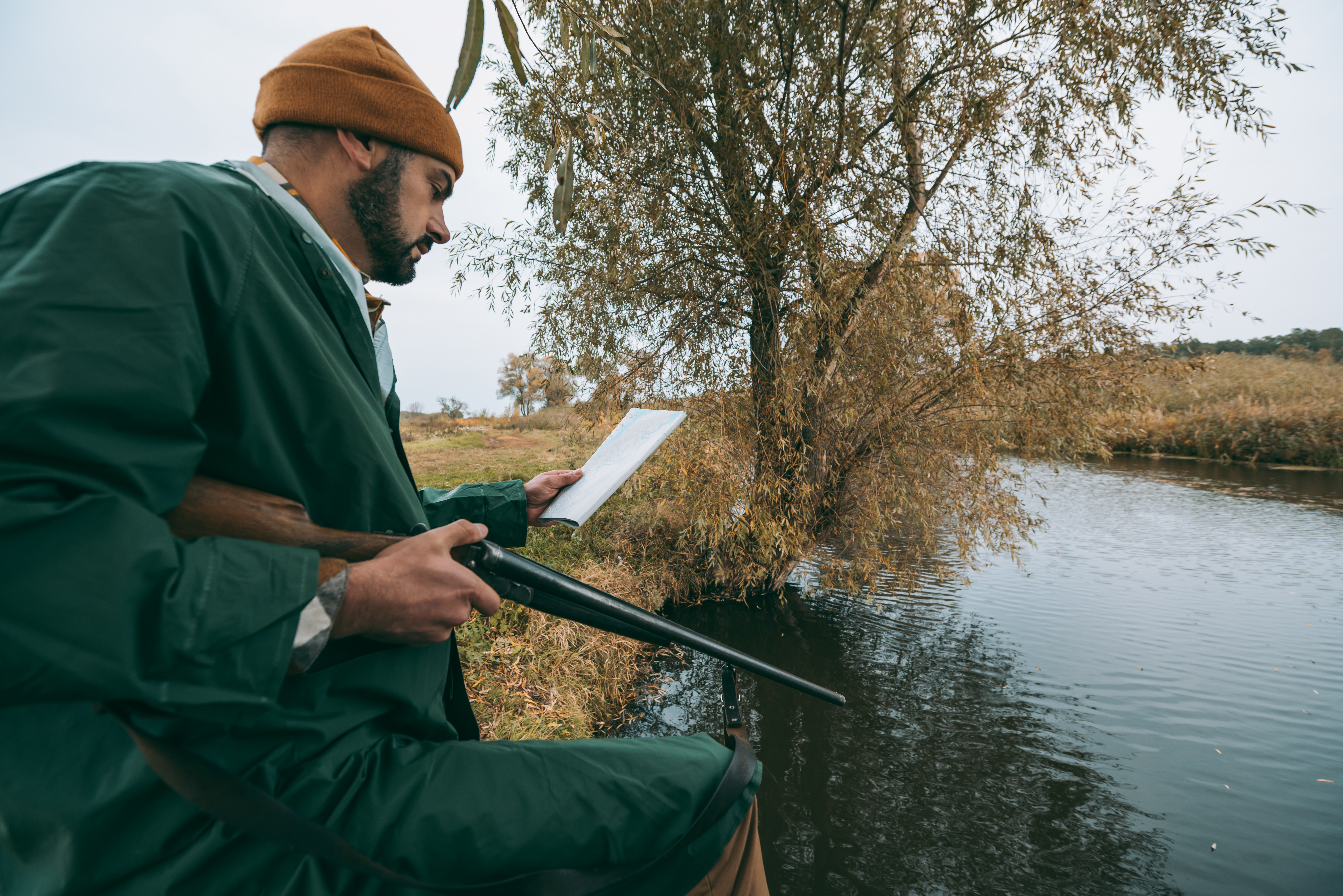 A duck hunter scouts in the field.