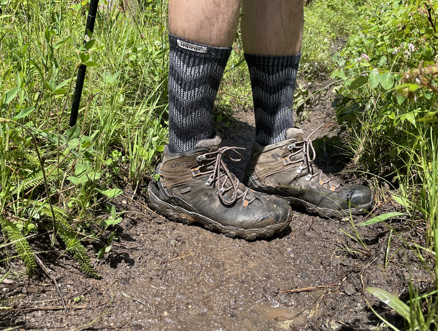 A pair of hiking boots on top of rainy mud