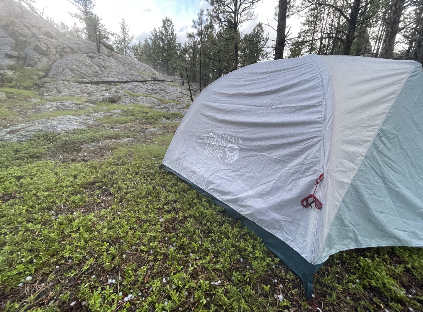 A white and gray camping tent in rainy weather
