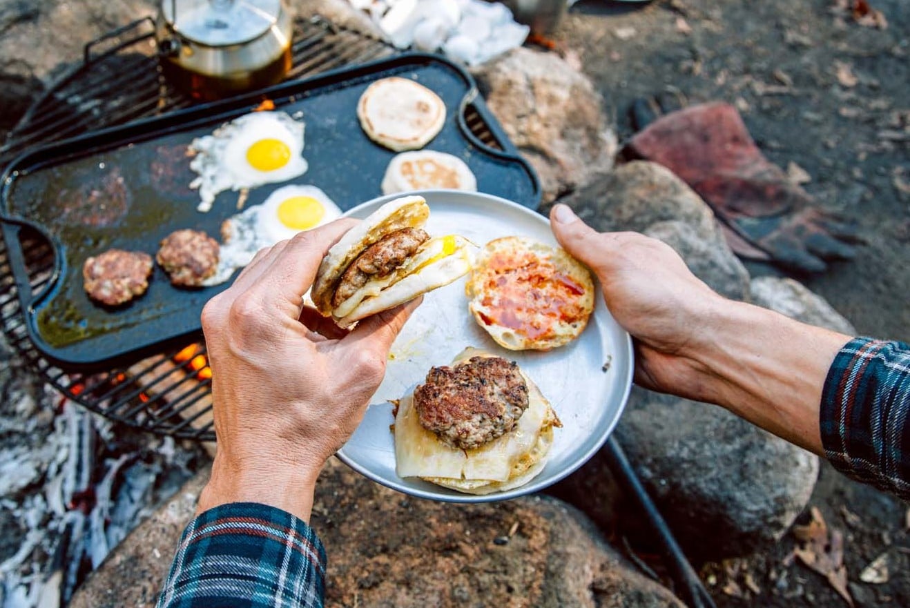 Egg and sausage breakfast sandwiches over a campfire sklillet 