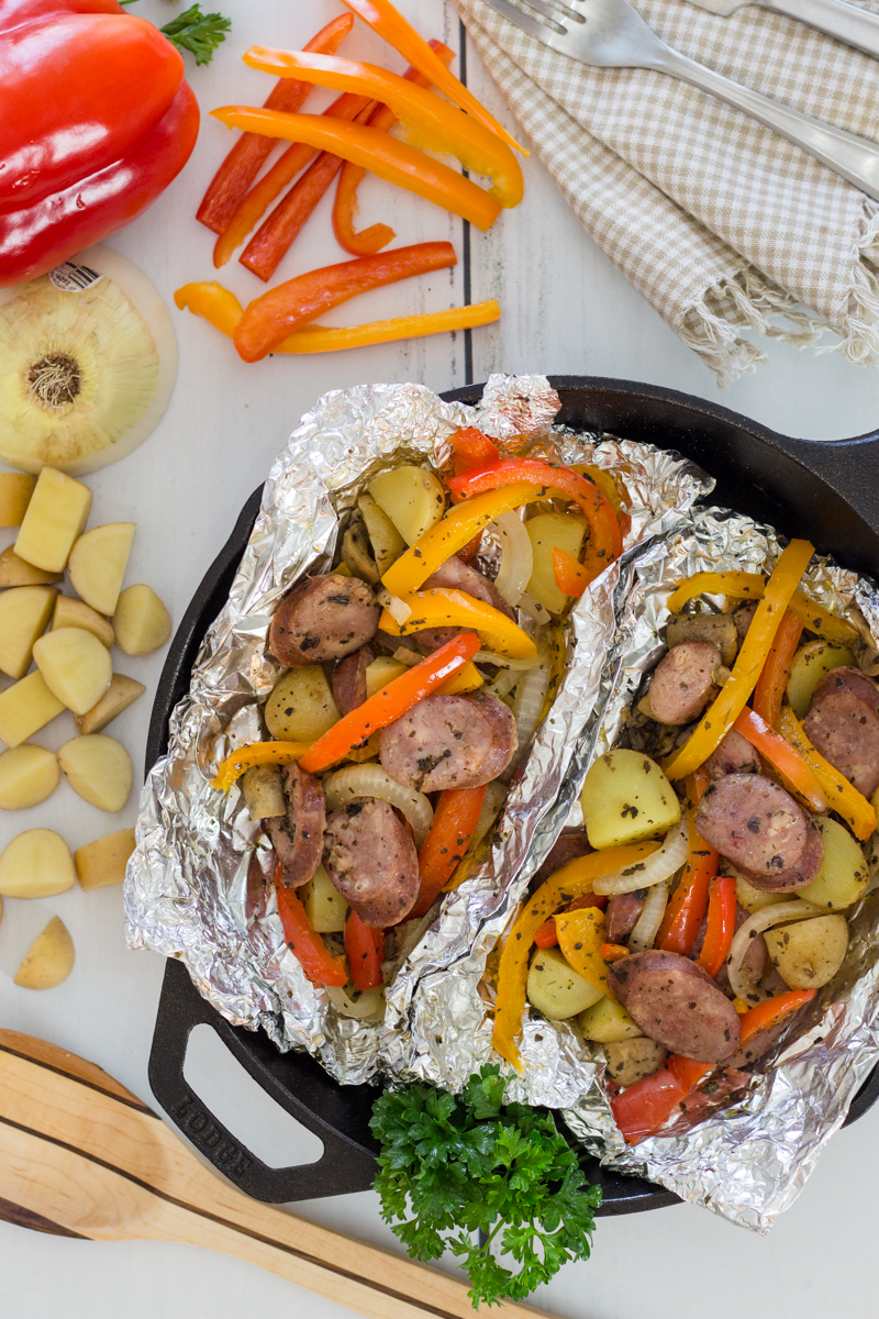 A sausage scramble with vegetables on top of tin foil in a skillet 