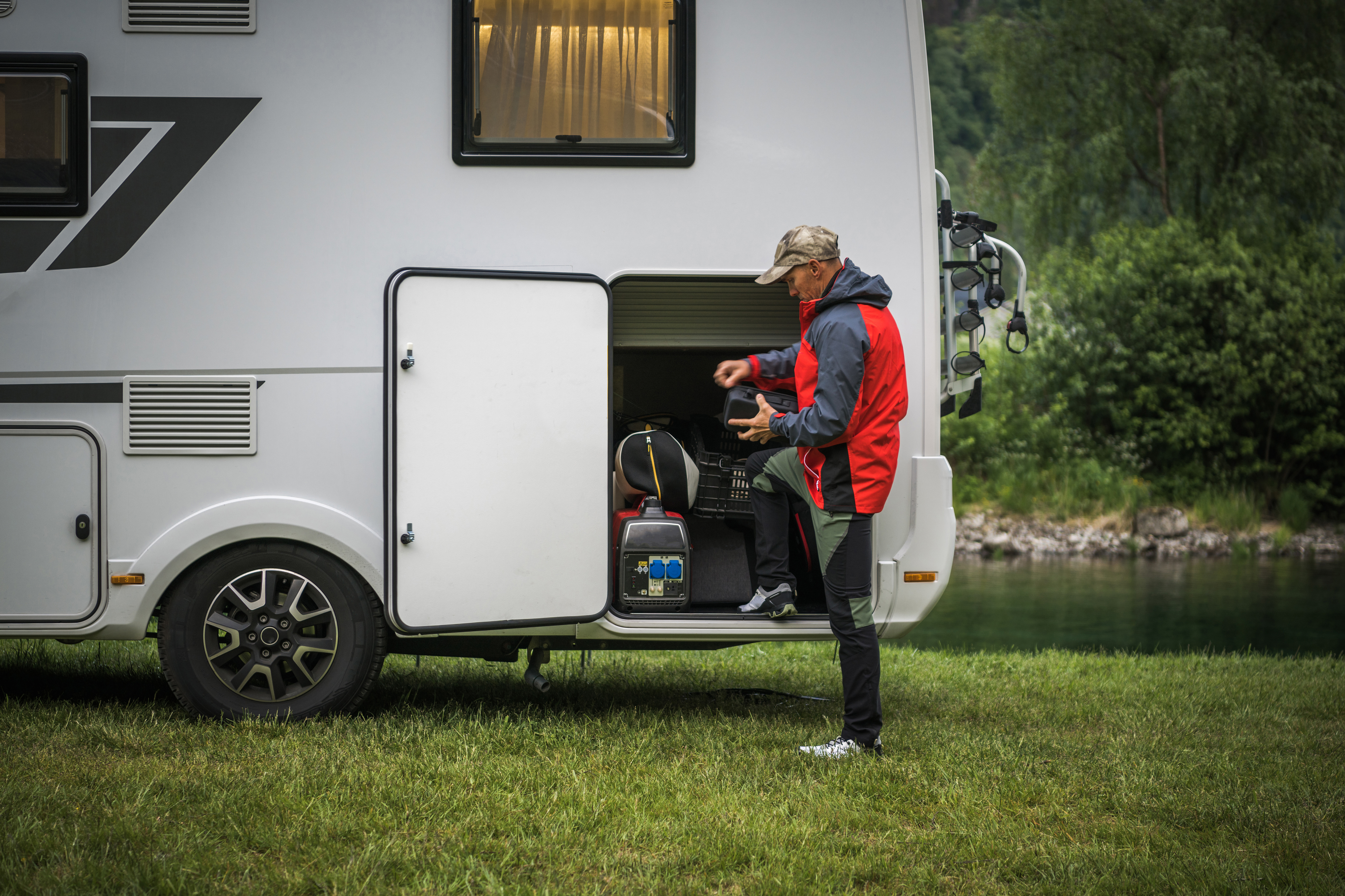  Man Leaving RV Park Campground and Checking His Motorhome Storage Before Heading a Road.