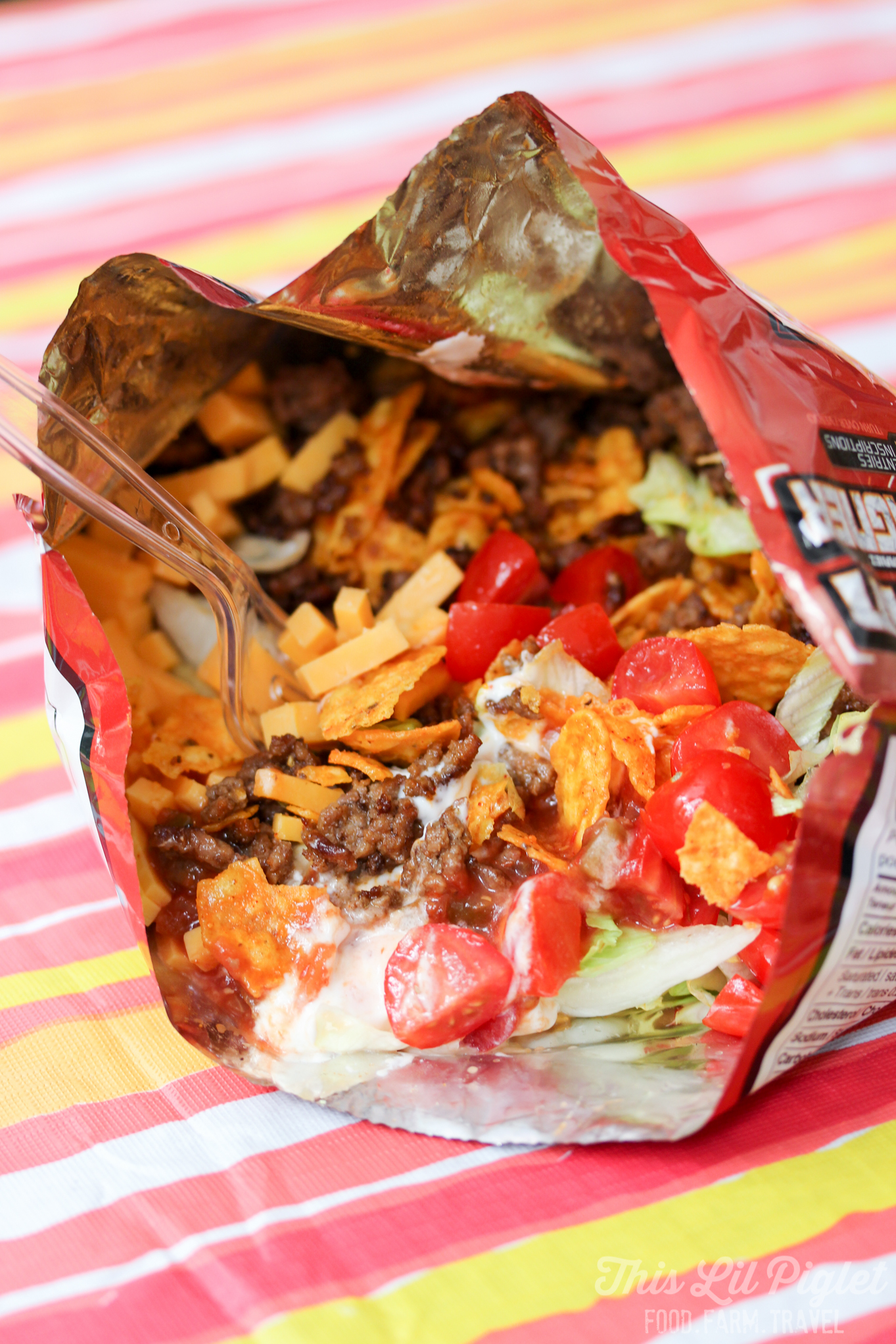 A deconstructed taco in a bag on a striped tablecloth