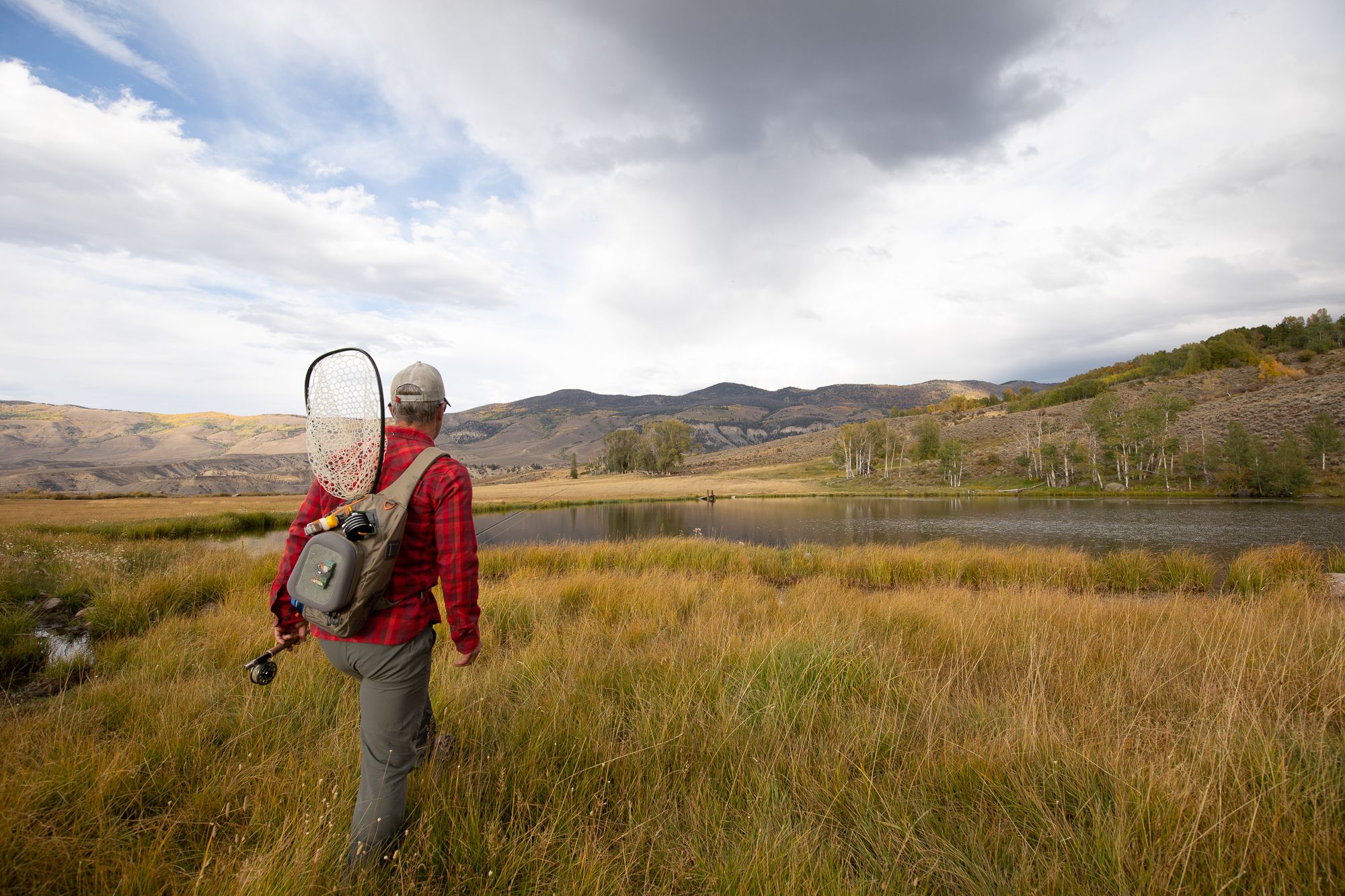 Person walking with a Fishpond Sling Pack on their back 