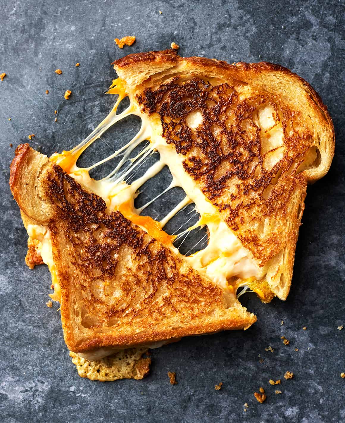 A grilled cheese sandwich being pulled apart