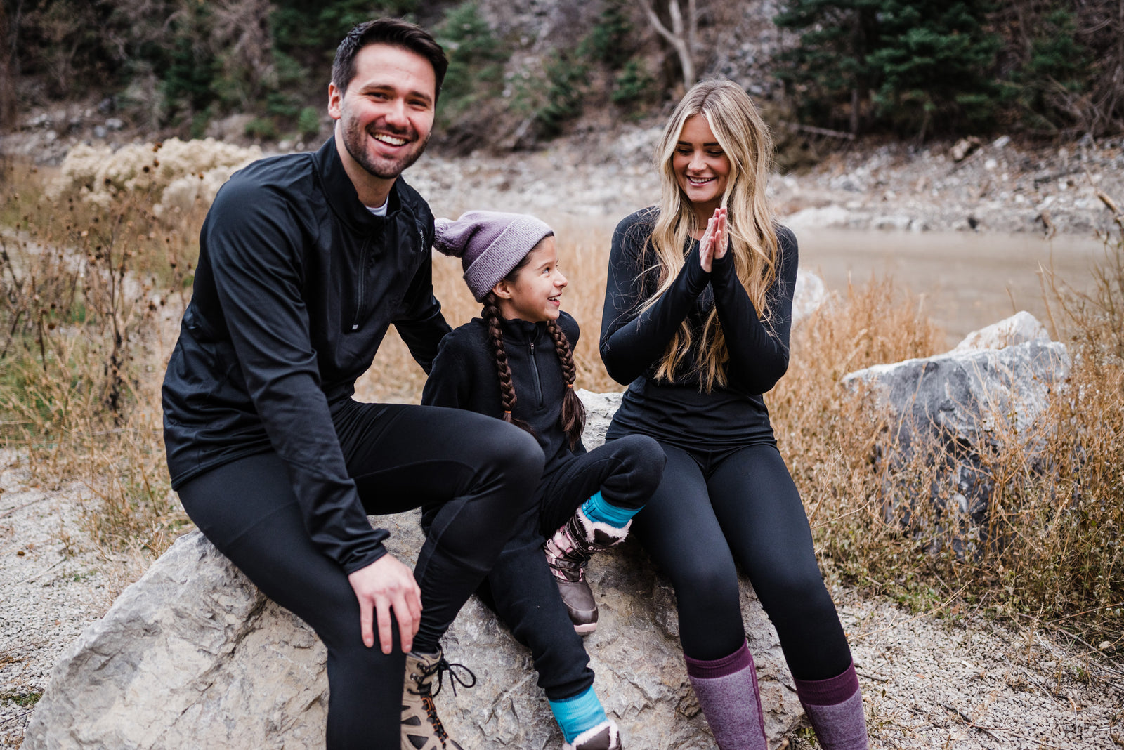 Two adults and a child wearing black clothing from Hot Chillys