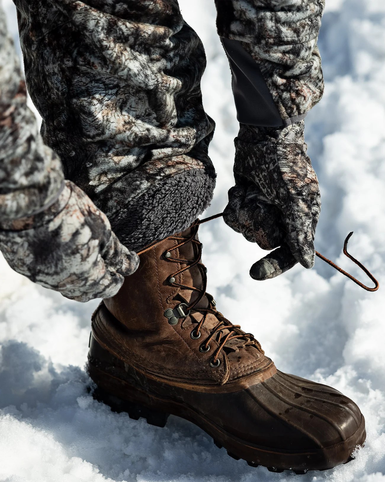 Person tying a snow boot while wearing ASIO Sherpa Lined Pants