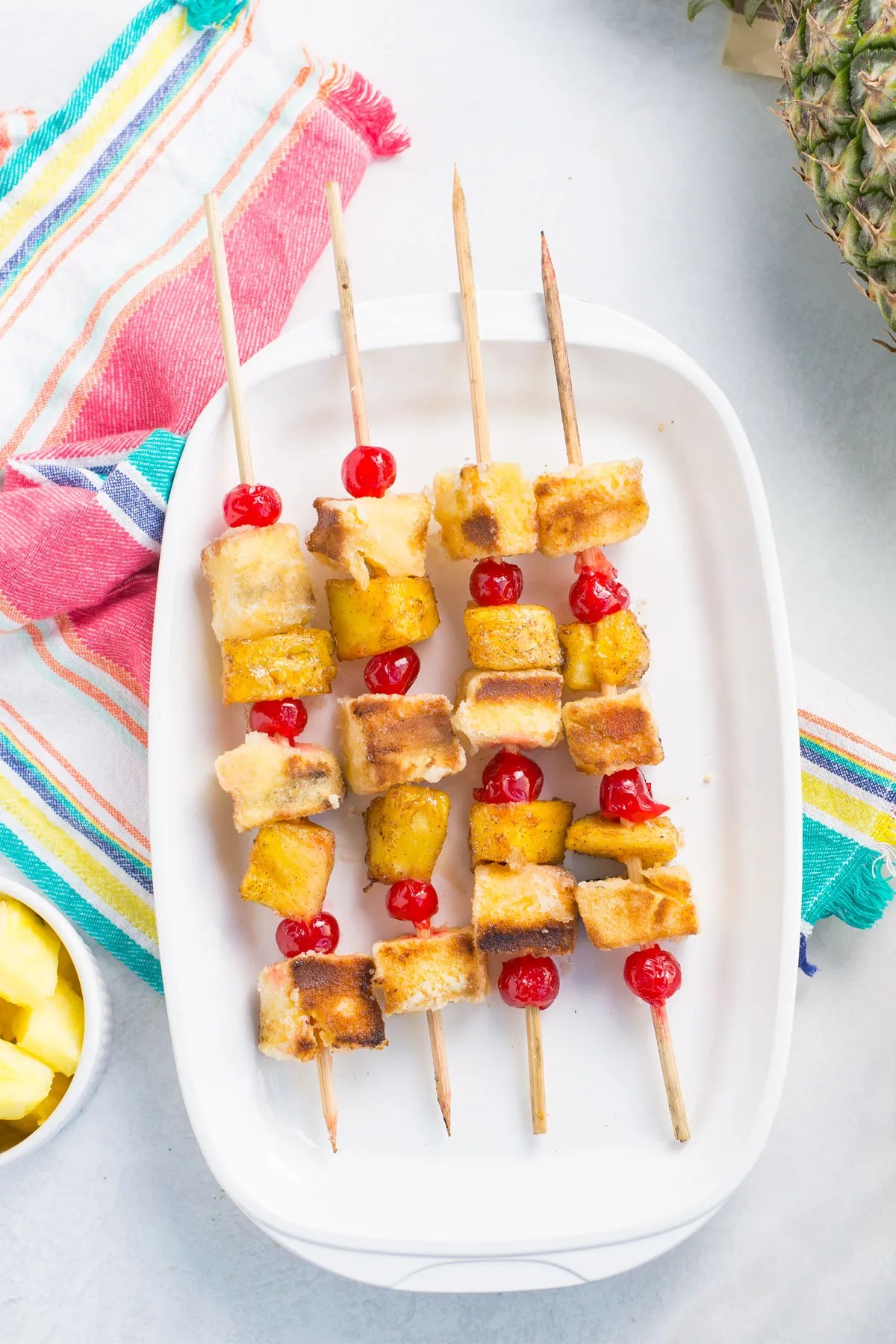 Pineapple kabobs on an ovular white tray