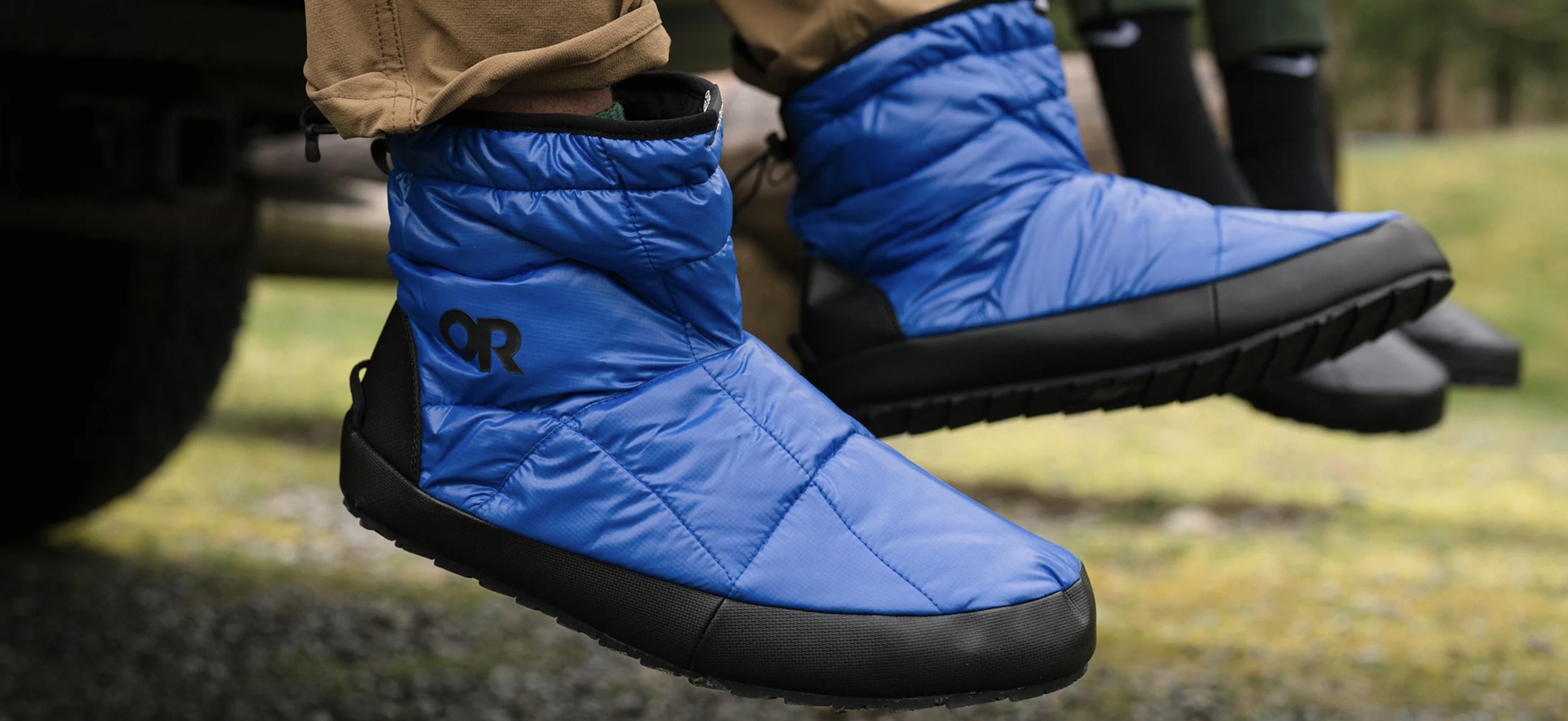 Person's feet dangling while wearing the Outdoor Research Tundra Trax Booties