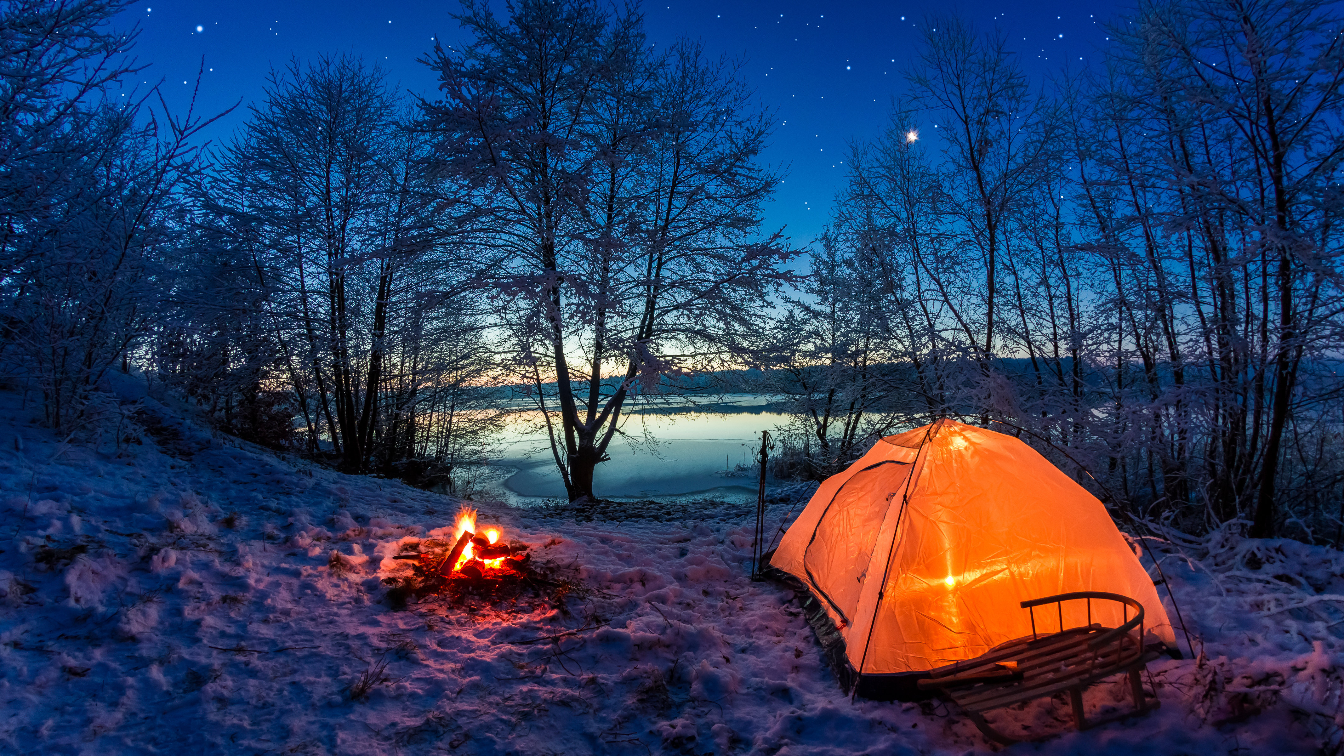 Sunrise on winter lake covered with snow at dusk