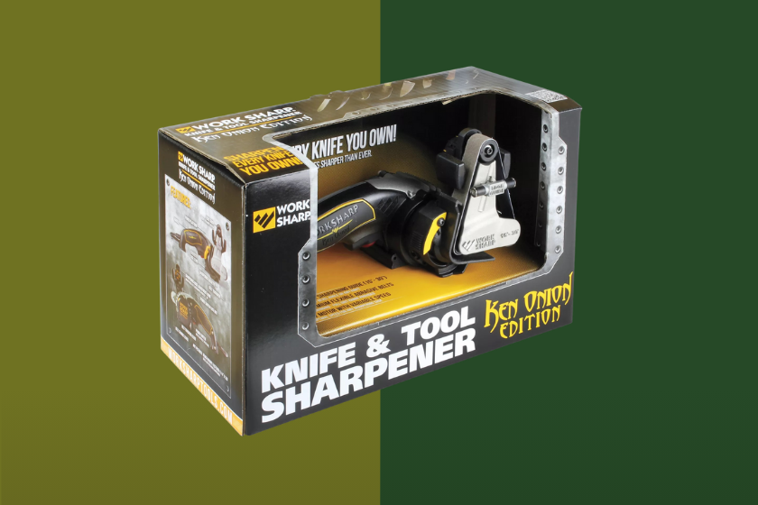 A silver and yellow tool sharpener placed over a green background