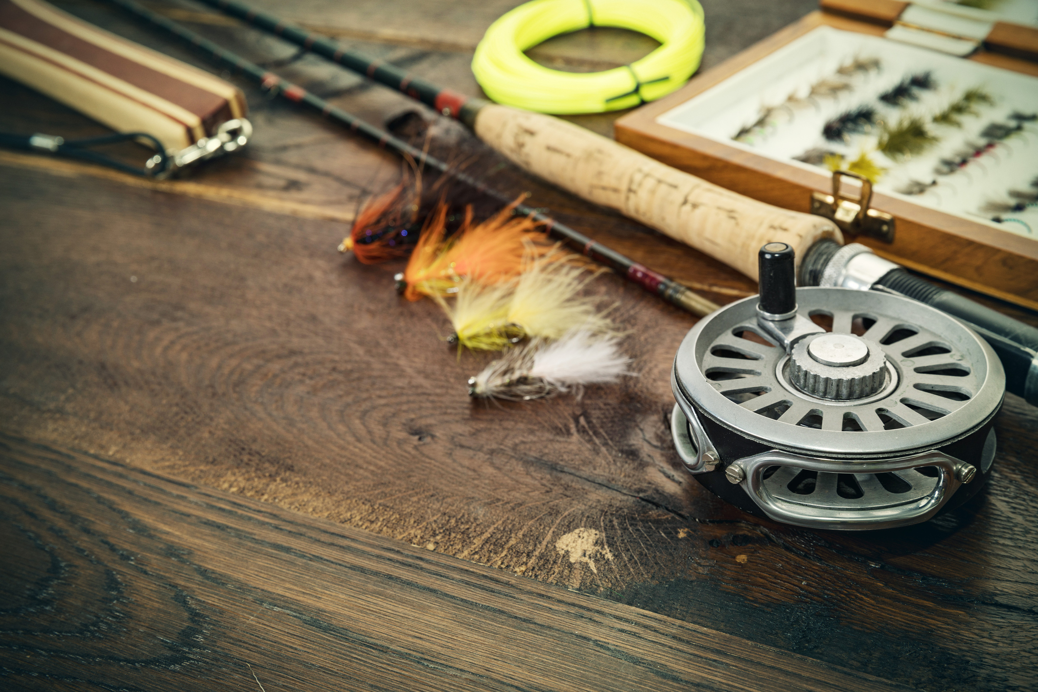 Fishing flies made of fur on a wooden table 