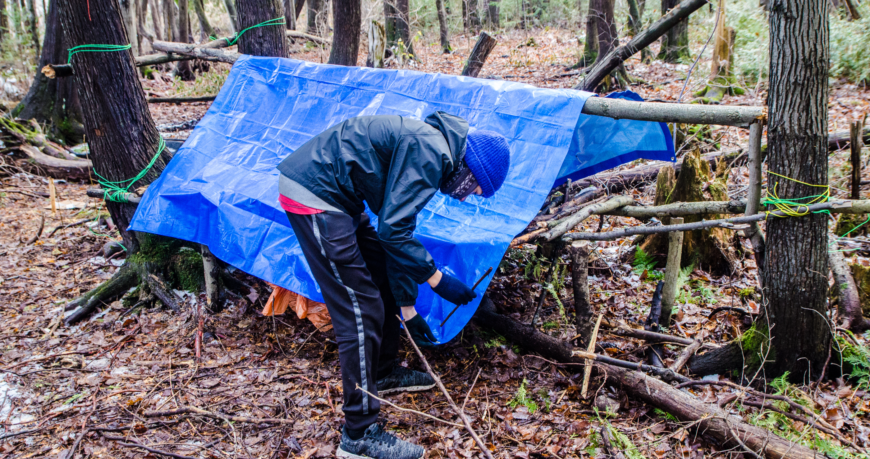 man building a shelter in the woods